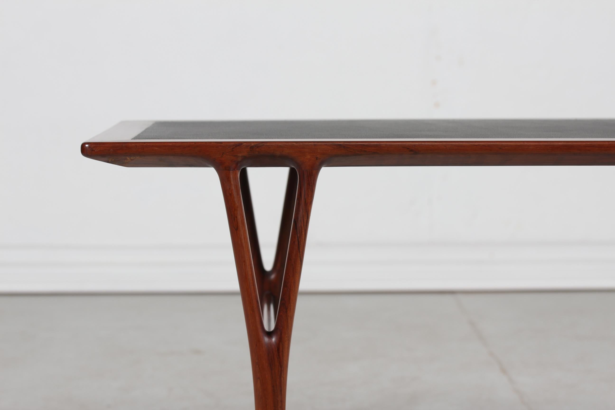 Helge Vestergaard Jensen (1917-1987) rectangular coffee table manufactured by master cabinetmaker Peder Pedersen, Copenhagen.
The table is made of rosewood with y-shaped legs and a black leather table top of newer date

Measures:
Length 120