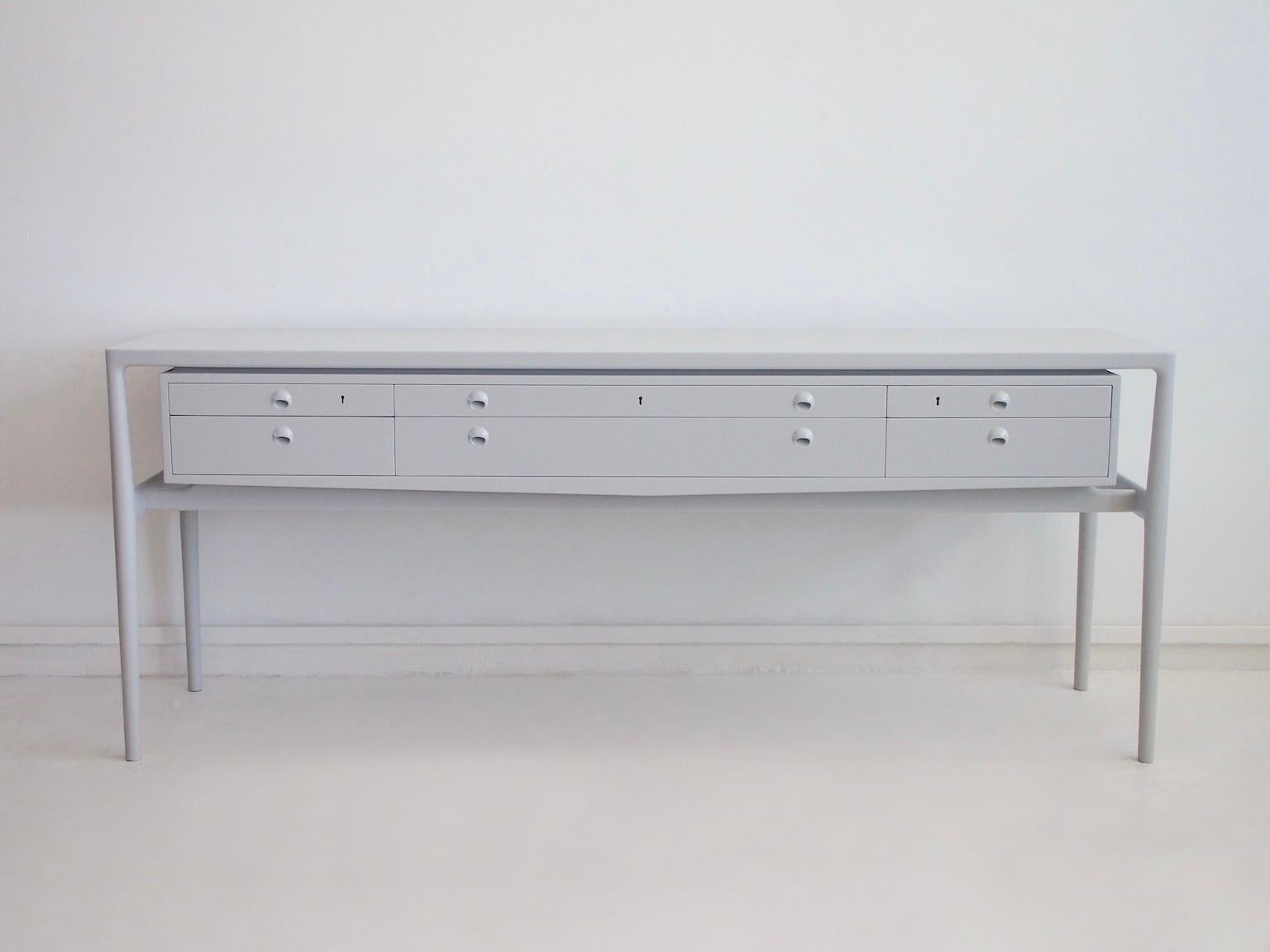 Elegant sideboard designed by Helge Vestergaard-Jensen circa 1955 and produced by master cabinetmaker Peder Pedersen. Made of veneered wood, unoriginal light grey color paint of later date. The console has recently been repainted. Very slightly