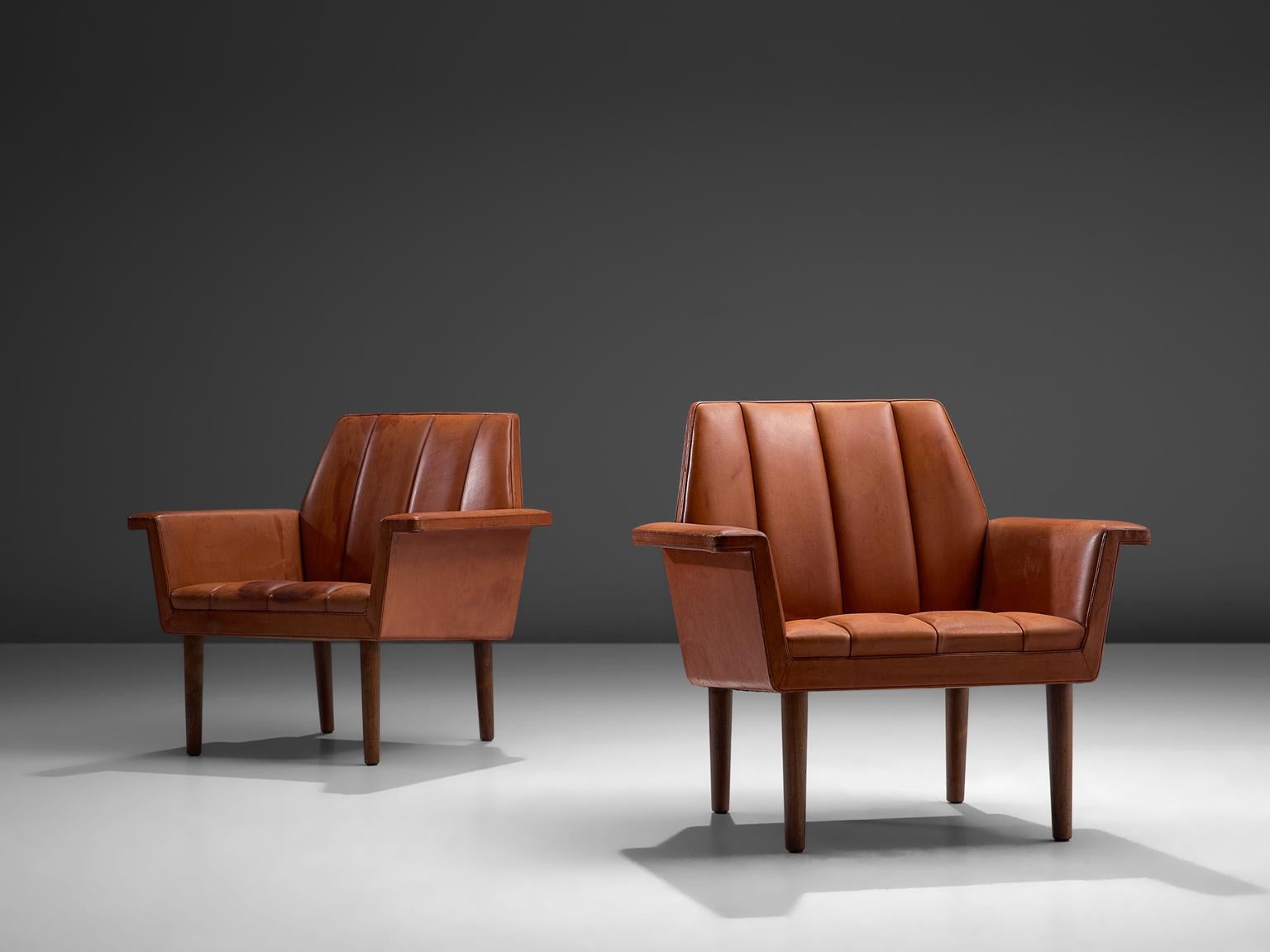 Helge Vestergaard Jensen for Peder Pedersen, pair of armchairs, cognac leather, wood, Denmark, 1960

Pair of terracotta-red leather armchairs that stand high on wooden legs, these chairs have a stately appearance. The seating is characterized by