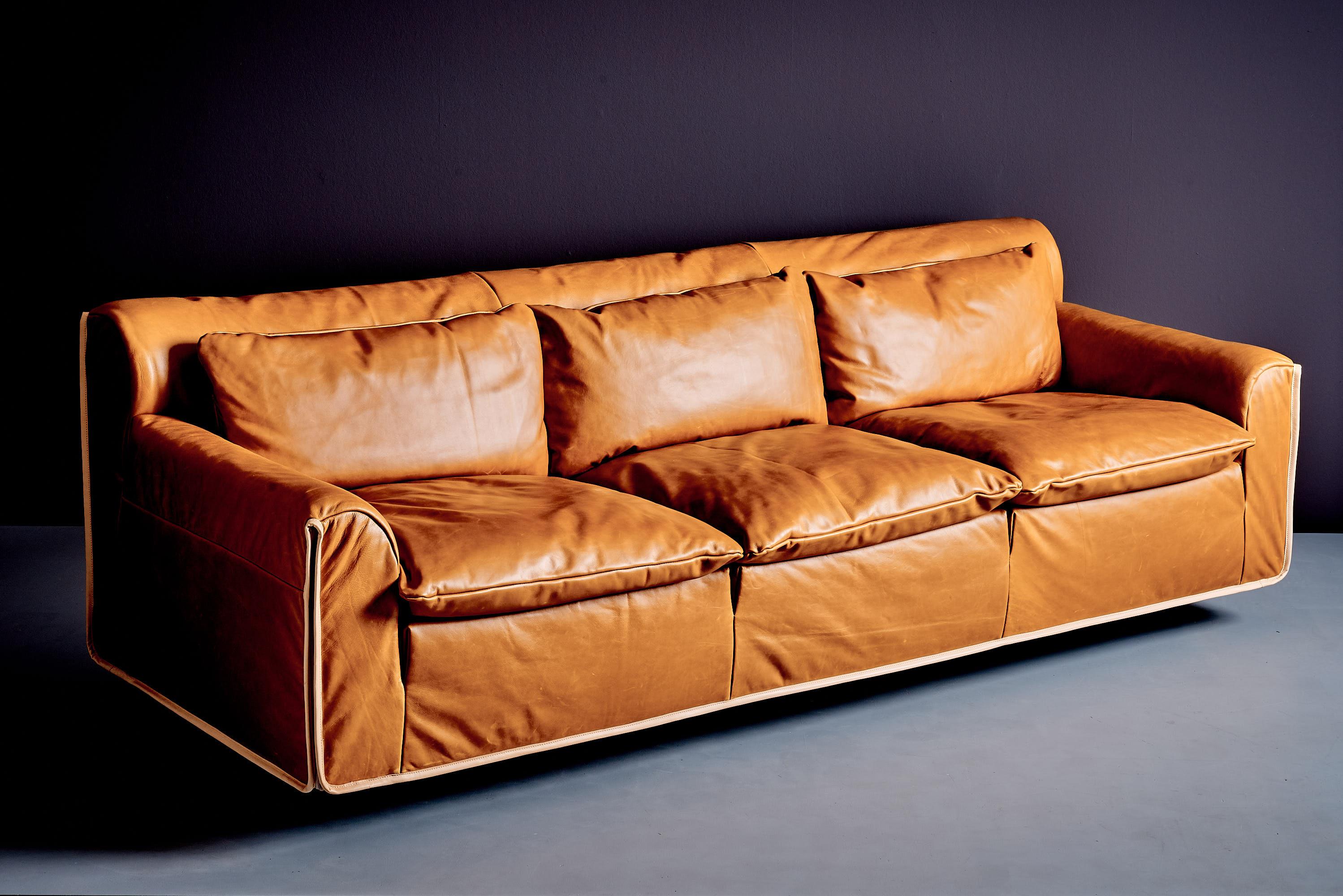 Das dreisitzige Ledersofa Heli wurde in den 1980er Jahren von Otto Zapf für Knoll International entworfen. Dieses postmoderne Design verbindet Luxus und moderne Schlichtheit auf zeitlose Weise. Das Sofa ist mit neu gepolstertem hellbraunem Leder und