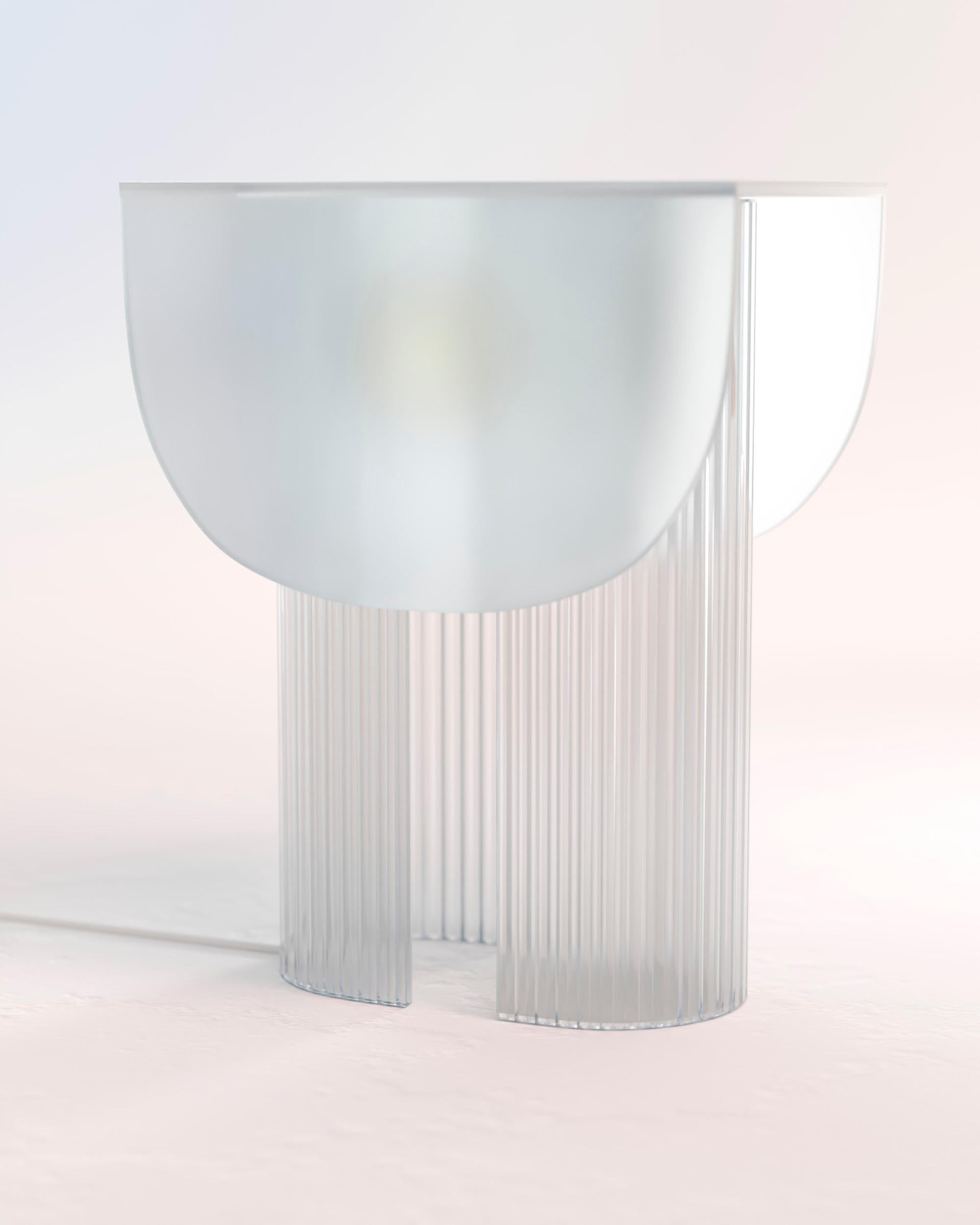 Helia Table Lamp by Glass Variations
Dimensions: W 22 x D 31 x H 40 cm
Materials: Glass. 

With this 100% glass table lamp Bina Baitel celebrates light and sun. Its curved patterned glass structure and the satin finished glass cap diffuse a soft