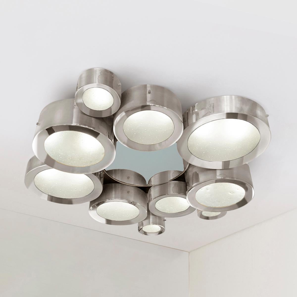The Helios ceiling light features an imposing composition of illuminated Murano glass shades gravitating around a central tinted mirror. The first images show the fixture in polished nickel with a gray center mirror-subsequent pictures show it in a