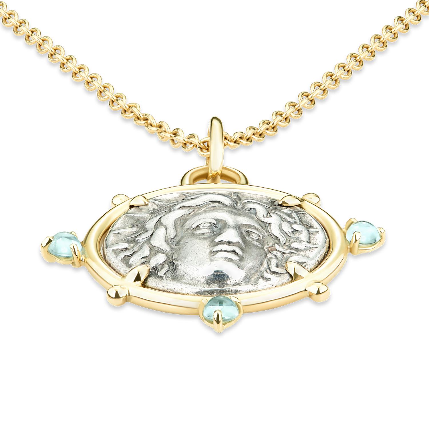 This DUBINI coin necklace from the 'Empires' collection features an authentic Rhodian silver coin minted circa 404-385 B.C. set in 18kt yellow gold with aquamarine cabochons.

DEPICTED ON THE COIN

Obverse: Radiate head of Helios
Reverse: Rose,