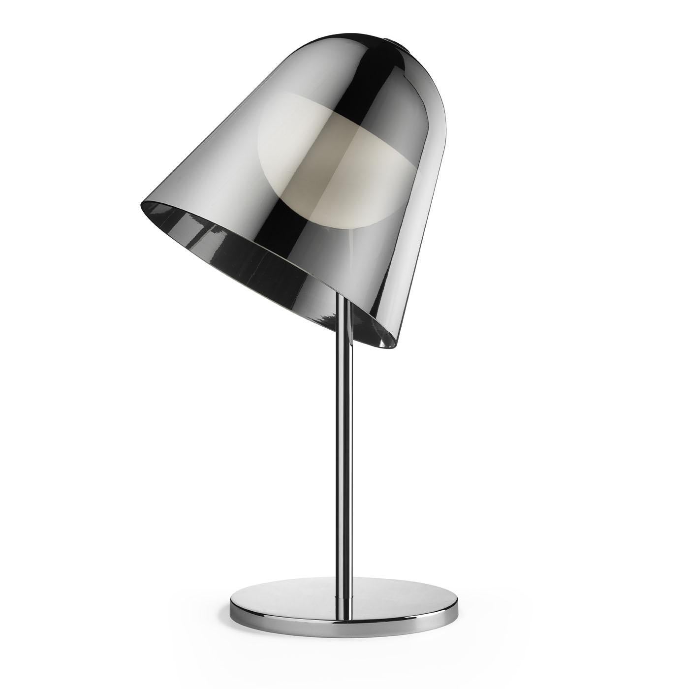 Superb for all customized illumination needs, a bell-like silvery glass shade marks this table lamp as a design cleverly synthesizing playfulness and elegance. A thin stem extending from a circular base traces the gleaming metal silhouette,