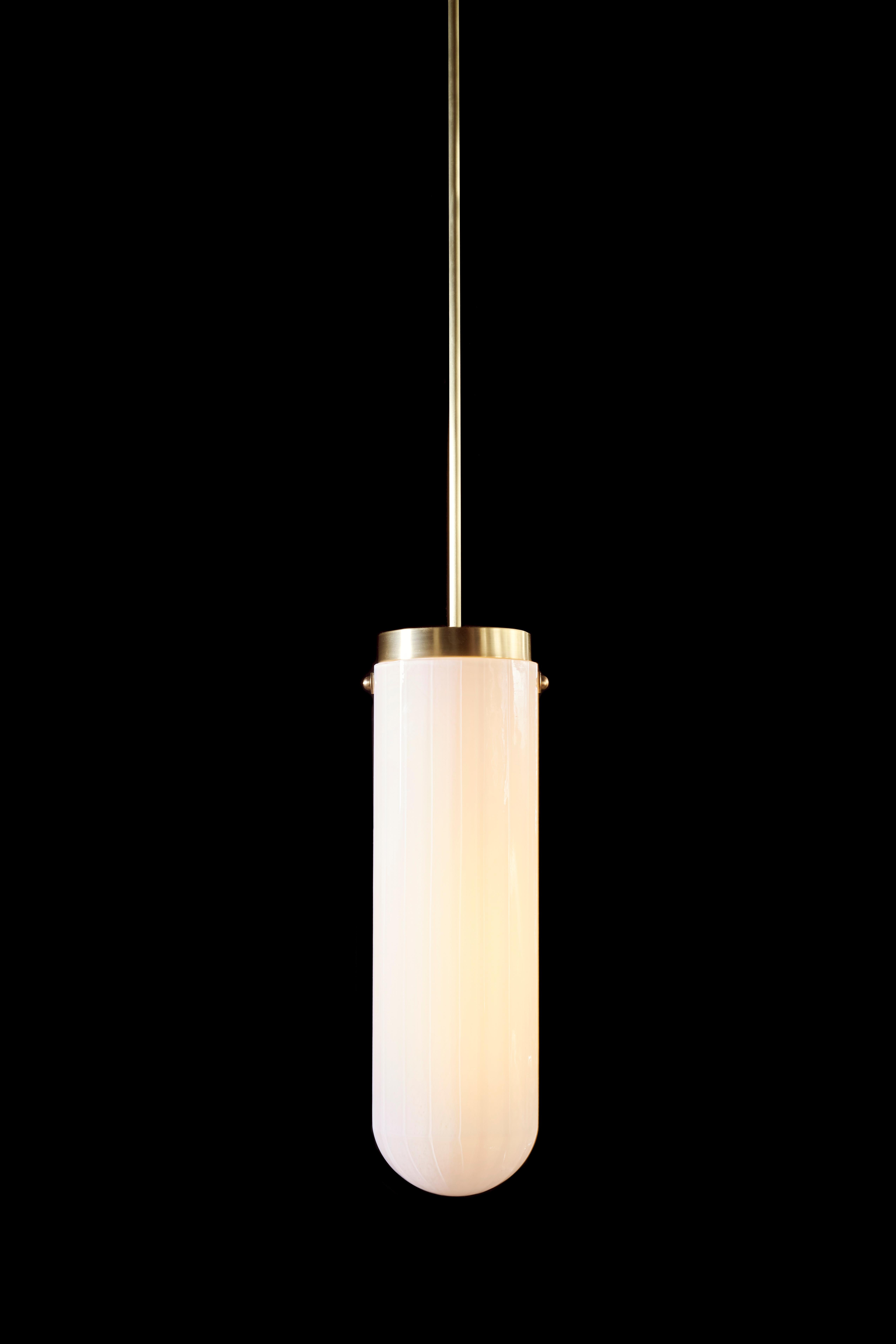Die von der Art Moderne inspirierte Hängeleuchte Helios gehört zur Serie Bianco Light and Space, streamline. Diese Pendelleuchte aus mundgeblasenem, facettiertem Glas in weißer Emaille mit Messingbeschlägen umfasst geschwungene Formen und lineare