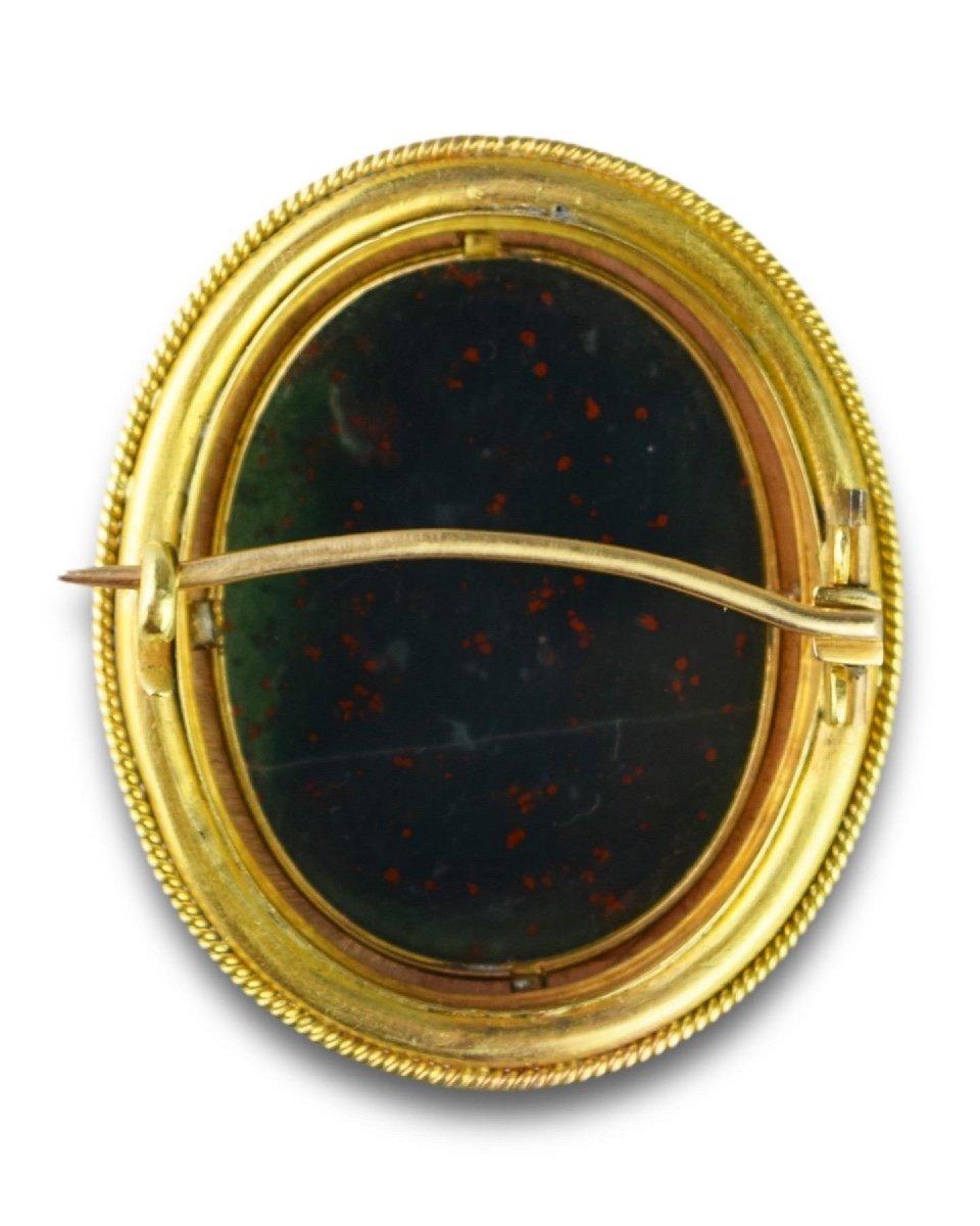 Un cammeo in eliotropio (pietra di sangue) raffigurante il profilo di Cristo.

Italiano, XVII secolo. 

Montato in una spilla in oro di alta caratura della metà del XIX secolo.

Il cammeo misura 3,2 x 2,4 cm, mentre la spilla misura 4,2 x 3,5