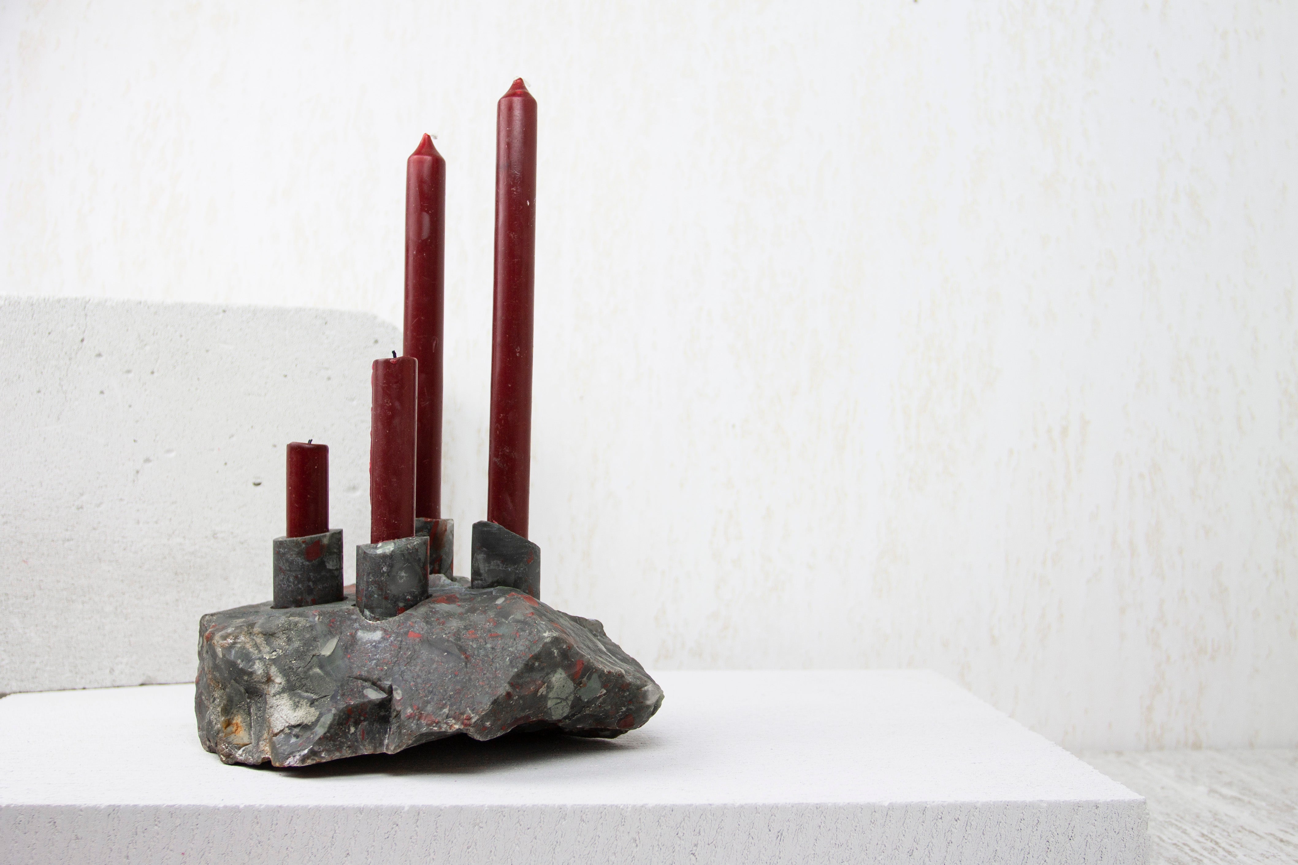 Heliotrope Seftonite Abra Candelabra by Studio DO
Dimensions: D 23 x W 18 x H 11 cm
Materials: Heliotrope Seftonite, aluminum.
5 kg.

Stone and fire are connected in an ageless bond. A sparkle created by clashing two stones with each other has been