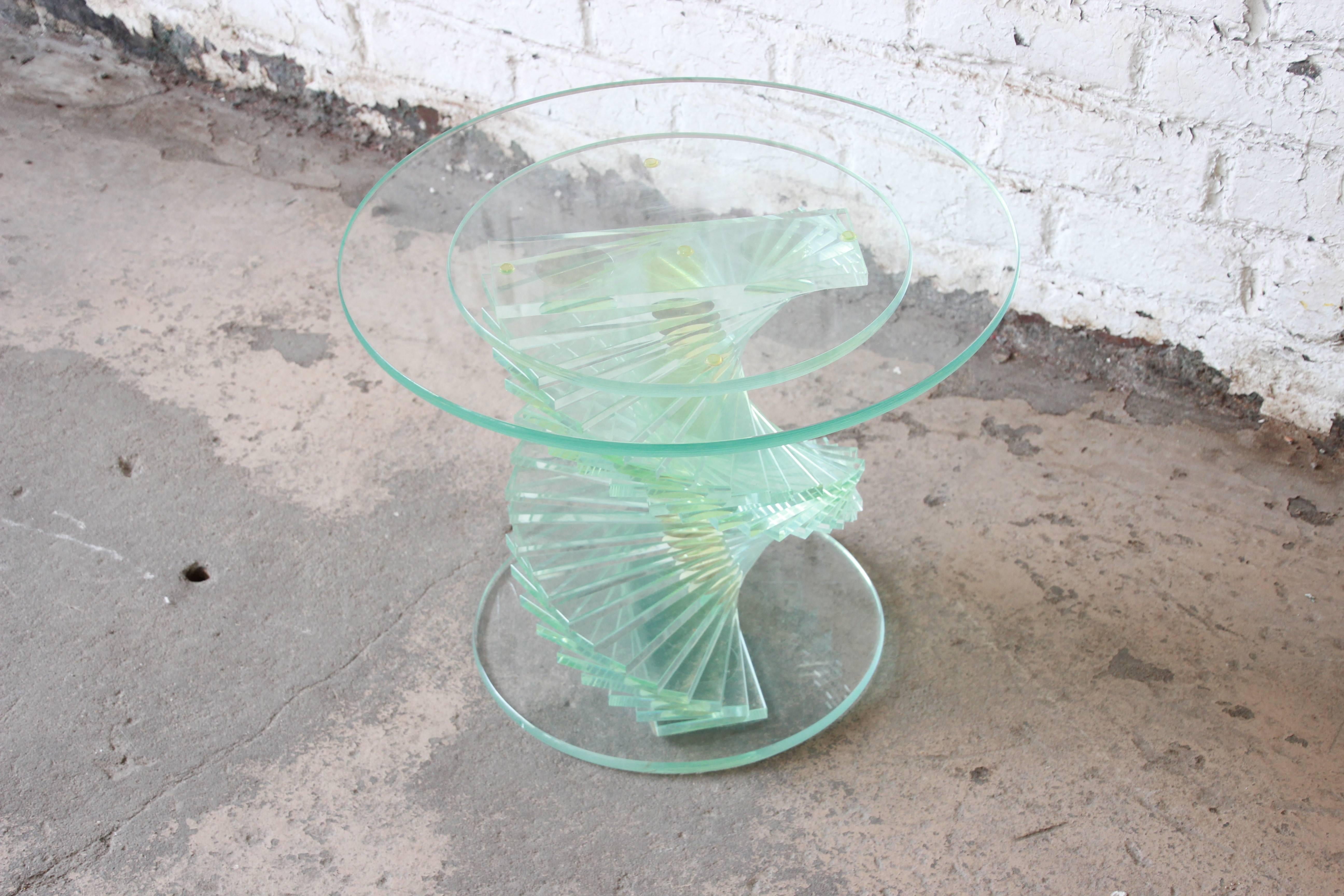 An outstanding vintage helix spiral stacked Lucite side table with a round glass top. The table features a unique helix spiral design, with stacked Lucite rectangles. A unique statement piece for any modern environment.
