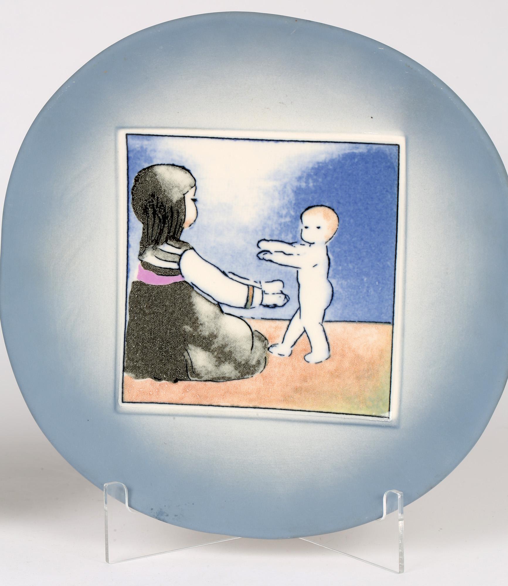 A fine pair vintage Arabia porcelain wall plates from the Mother and Child Series by Heljä Liukko-Sundström (b.1938) for Arabia, Finland and made in 1983. The wall plates are of rounded shape with squared off side edges and both have a raised square