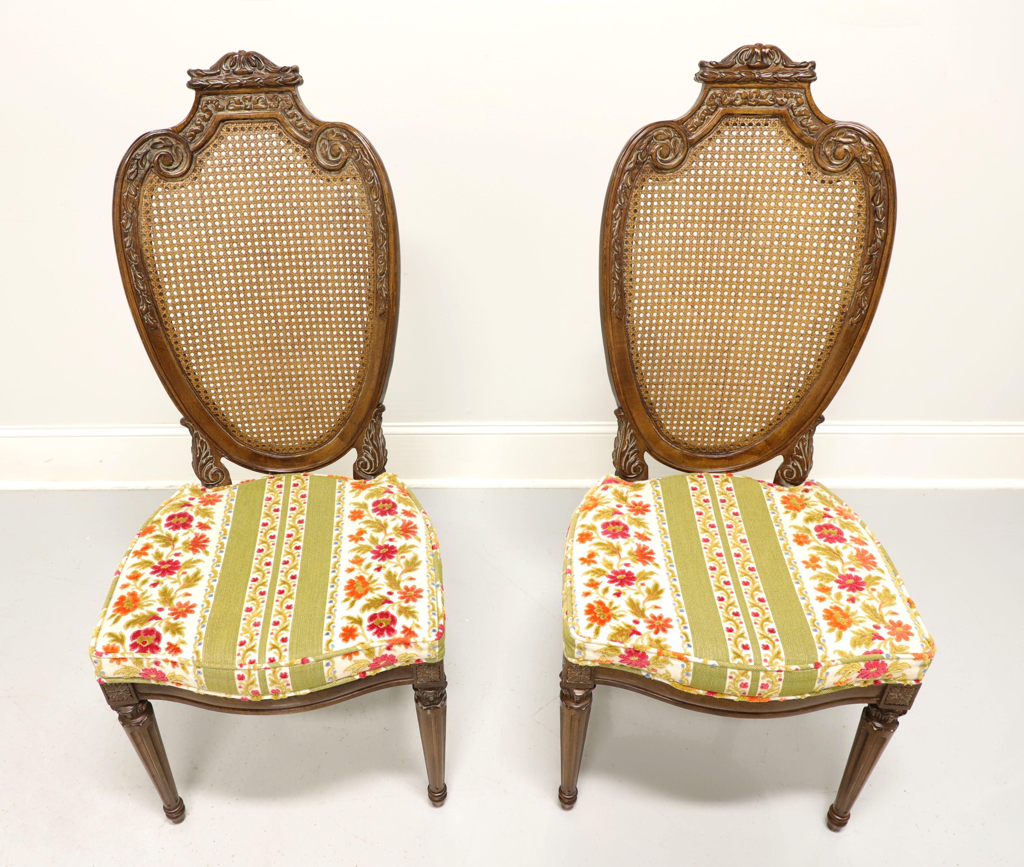 Paire de chaises latérales de salle à manger de style Louis XVI de style provincial français par Hellam. Noyer, légèrement usé, avec dossiers ovales cannelés et sculptés comme des boucliers, sièges tapissés de tissu brocart floral, tablier sculpté,