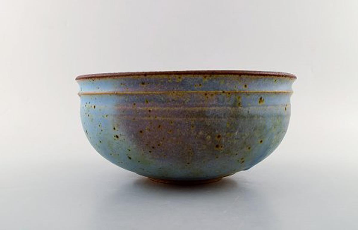 Helle Alpass (1932-2000). Large bowl of glazed stoneware in beautiful light blue glaze with iron spots, 1960s-1970s.
Stamped.
Measures: 25 x 11.5 cm
In very good condition.
Helle Allpass was a master-educated Danish ceramist, and educated from