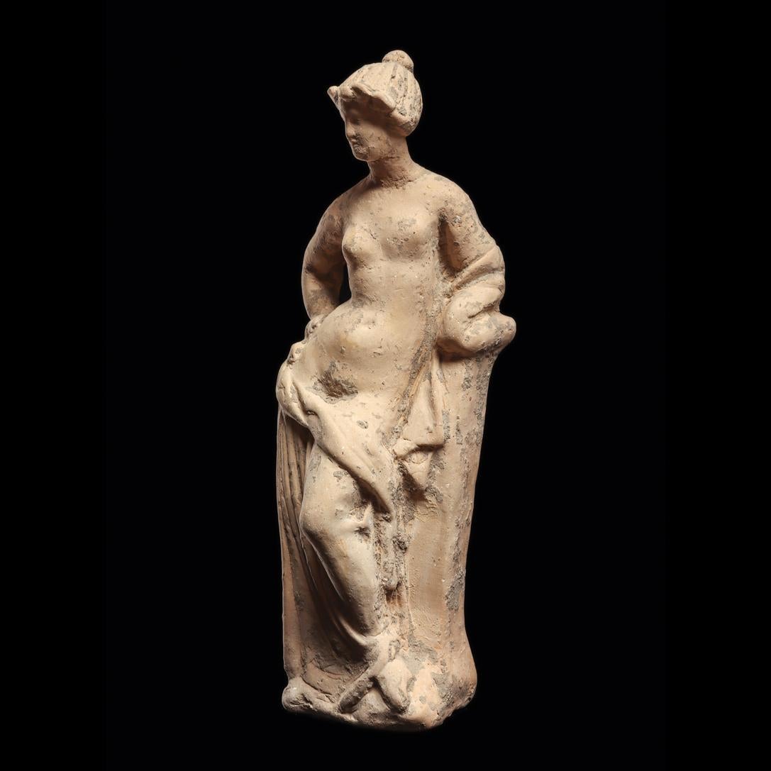 statuette of aphrodite leaning on a pillar