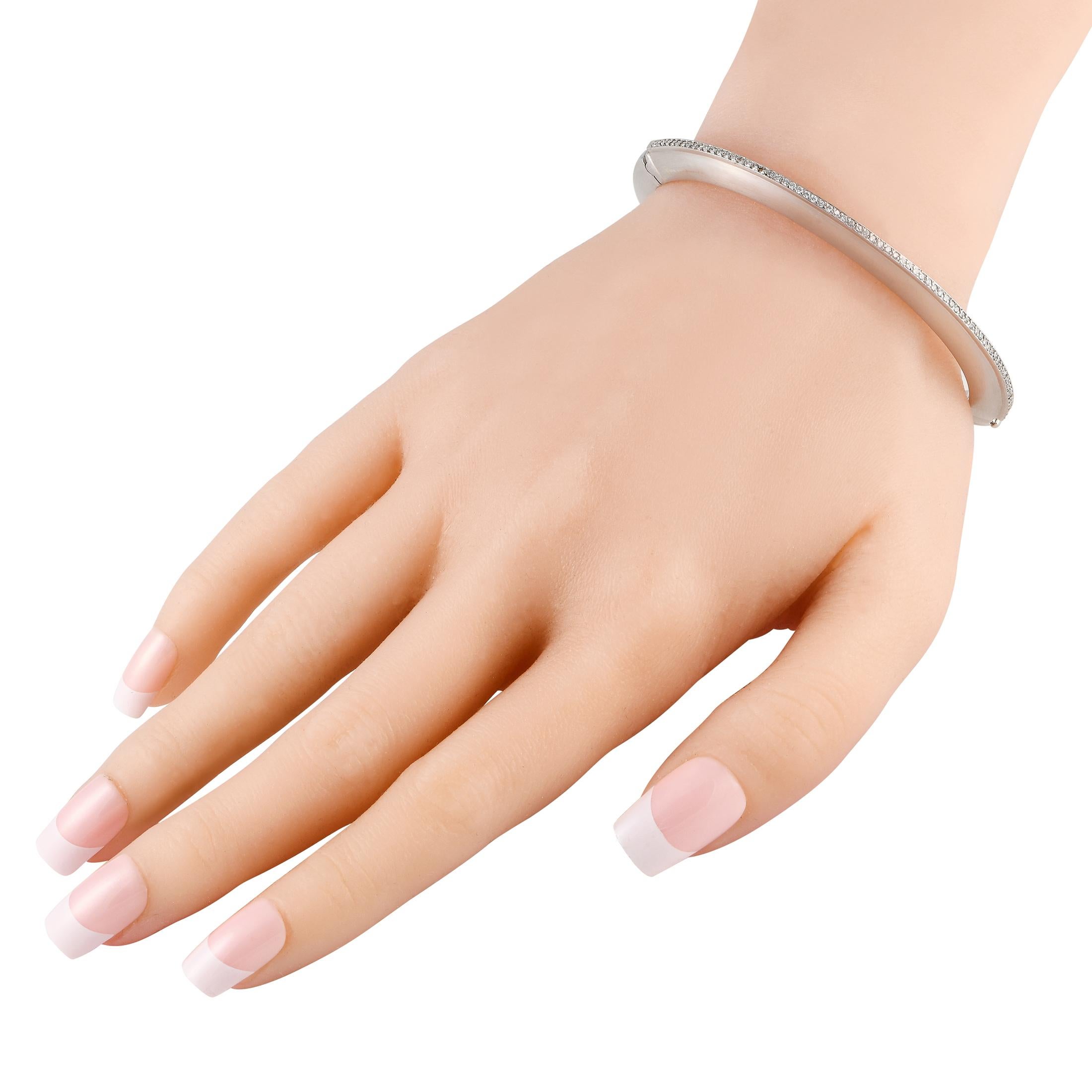 Dieser elegante Hellmuth-Armreif ist ideal für alle, die eine minimalistische Ästhetik bevorzugen. Glänzendes 18-karätiges Weißgold zieht sofort die Blicke auf sich, während eine Reihe funkelnder Diamanten mit einem Gesamtgewicht von 0,35 Karat für