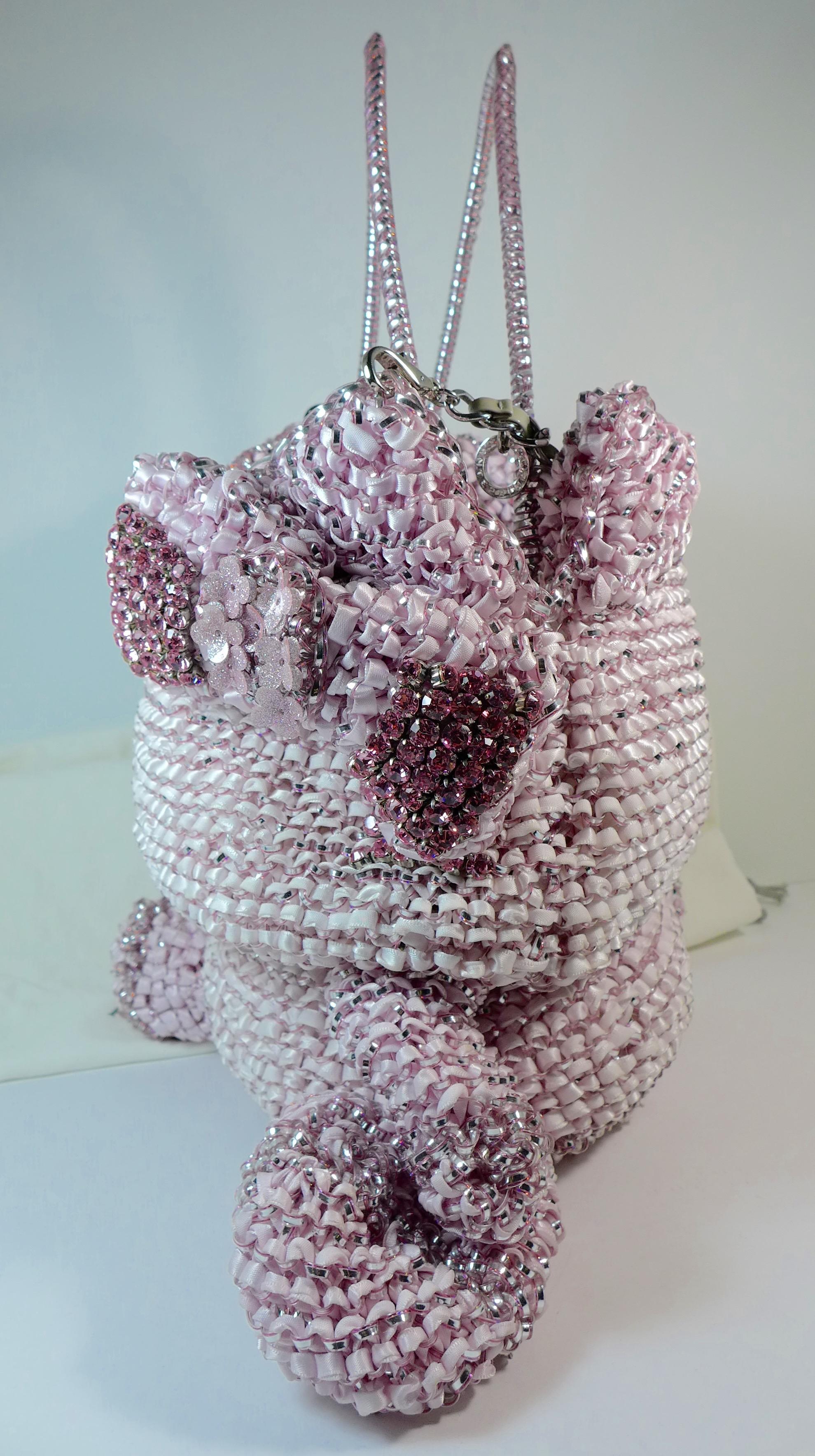 This unique ribbon and plastic woven bag is in the shape of Hello Kitty. The bag features pink rhinestone embellishments and a silver detachable chain strap as well as plastic handles. It comes with a dust bag. 

Measurements in Inches:
Length: 8