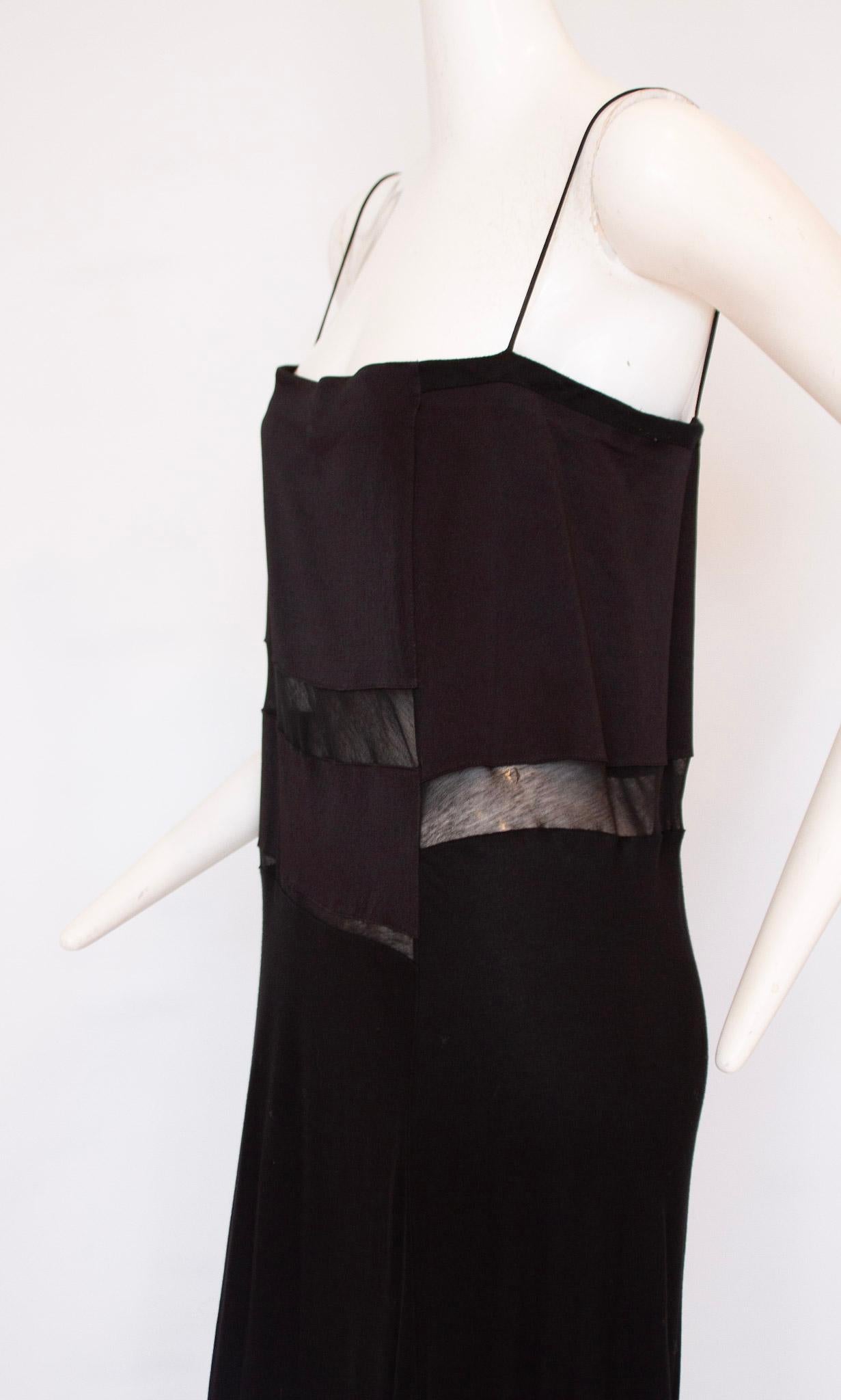 The Helmut Lang Black Maxi Dress features silk, sheer panels at the midriff and bottom, adding a subtle touch of sophistication. With a timeless all-black aesthetic, this dress has a look that will never go out of style. Its flattering silhouette