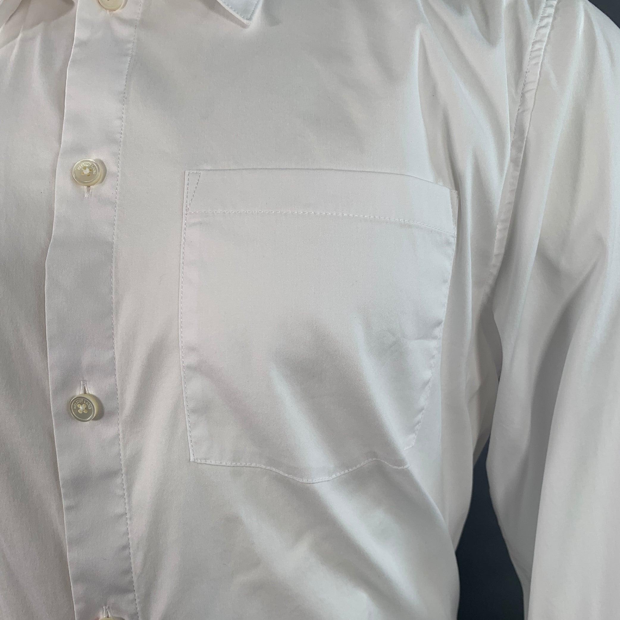 HELMUT LANG Langarmhemd
aus weißem Baumwollmischgewebe, mit geschwungenem Kragen, einer Tasche, tonalem Textdruck auf dem oberen Rücken und Knopfverschluss. Sehr guter gebrauchter Zustand. Kleine Flecken auf der Innenseite des Kragens. 

Markiert:  
