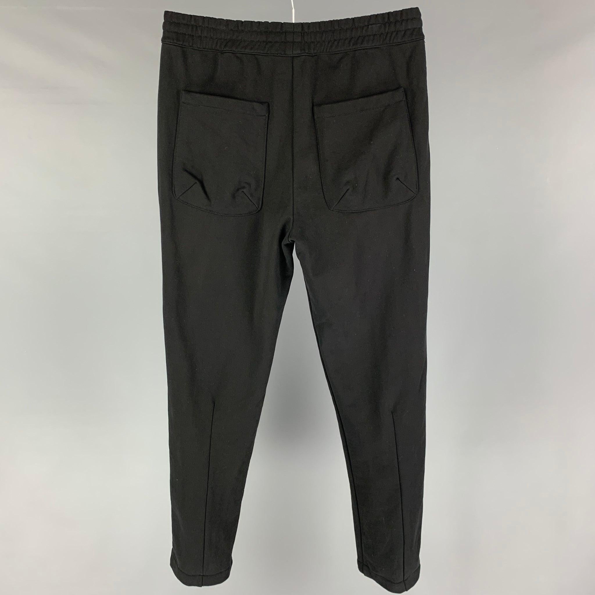 HELMUT LANG pants comes in a black cotton featuring a pleated style, elastic waistband, and a zip fly closure.
Excellent
Pre-Owned Condition. 

Marked:   S 

Measurements: 
  Waist: 30 inches Rise: 12 inches Inseam: 31 inches Leg Opening: 12 inches
