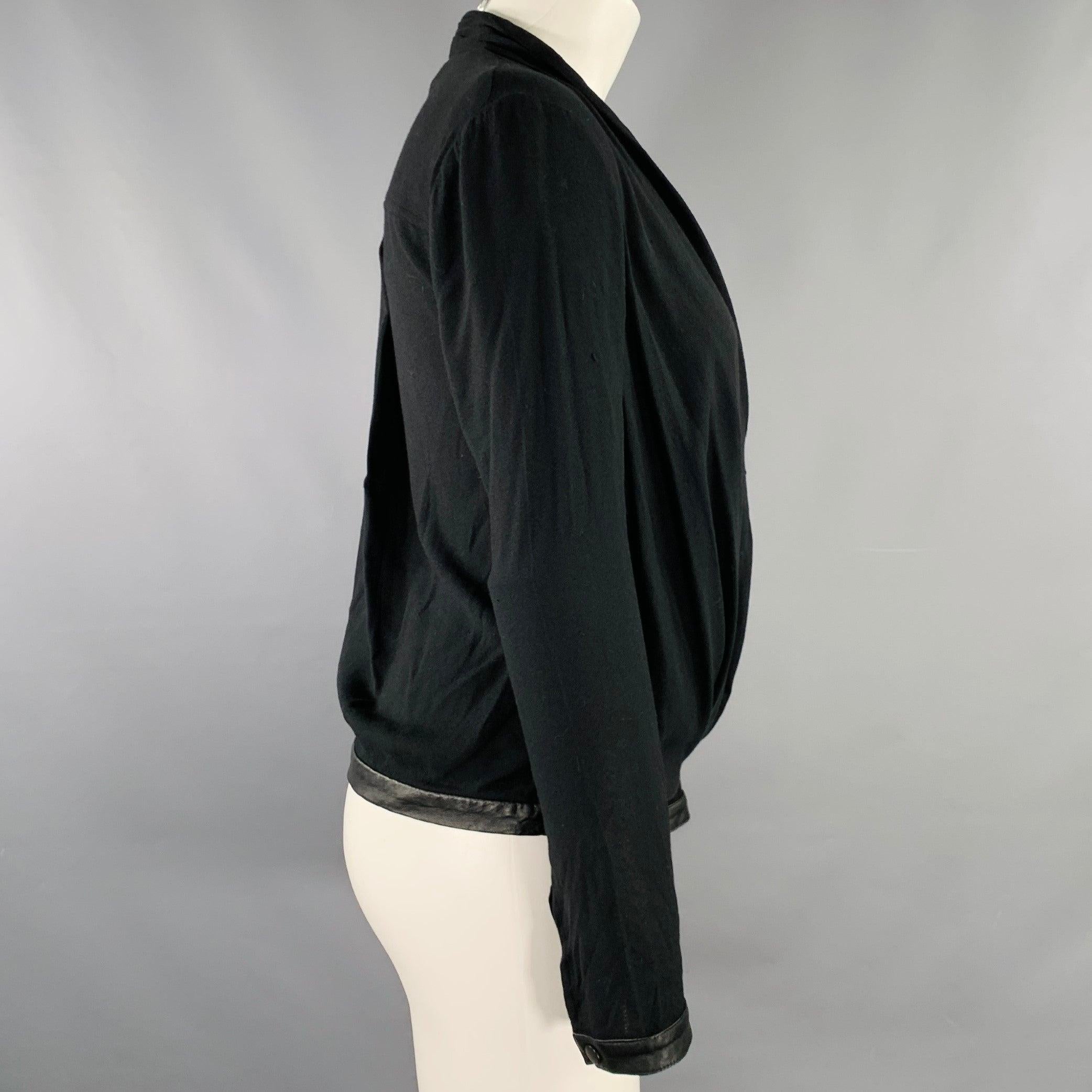 HELMUT LANG - Top décontracté
en viscose mélangée noire, avec un style faussement enveloppant, une poche, et des bordures en cuir aux poignets et à l'ourlet. Fabriqué aux Etats-Unis. Très bon état. Signes mineurs d'usure. 

Marqué :   S 

Mesures :