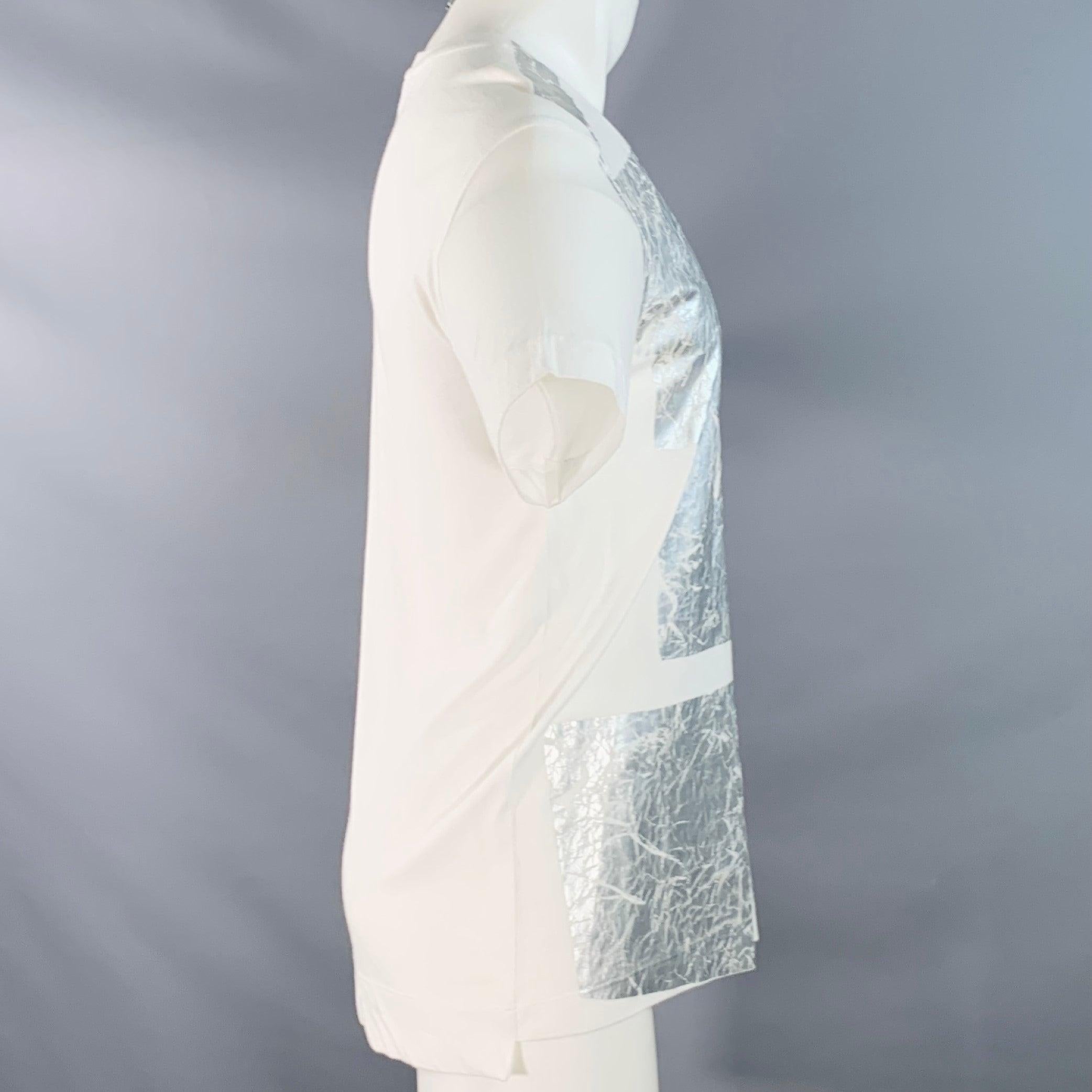 T-shirt HELMUT LANG
en jersey de coton blanc mélangé à du modal, avec un imprimé graphique argenté métallique et des détails en relief, des manches courtes et un col ras du cou. Fabriqué aux Etats-Unis. Très bon état. Léger boulochage et signes