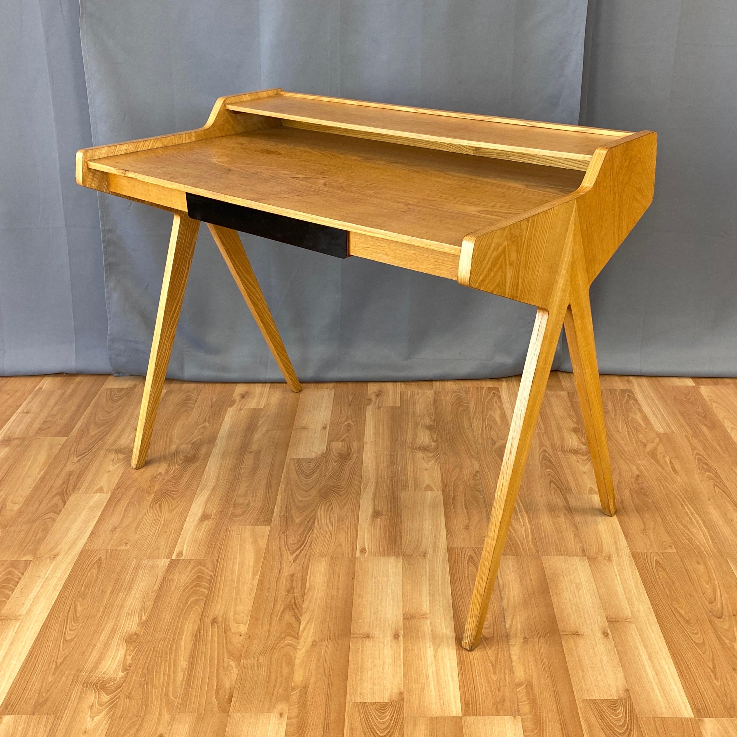 A 1950s elm desk on compass-style legs with drawer and cubby, designed by German architect Helmut Magg for the international European furniture competition “Neue Gemeinschaft für Wohnkultur”, and produced by WK Wohnen Möbel.

Modernist distillation
