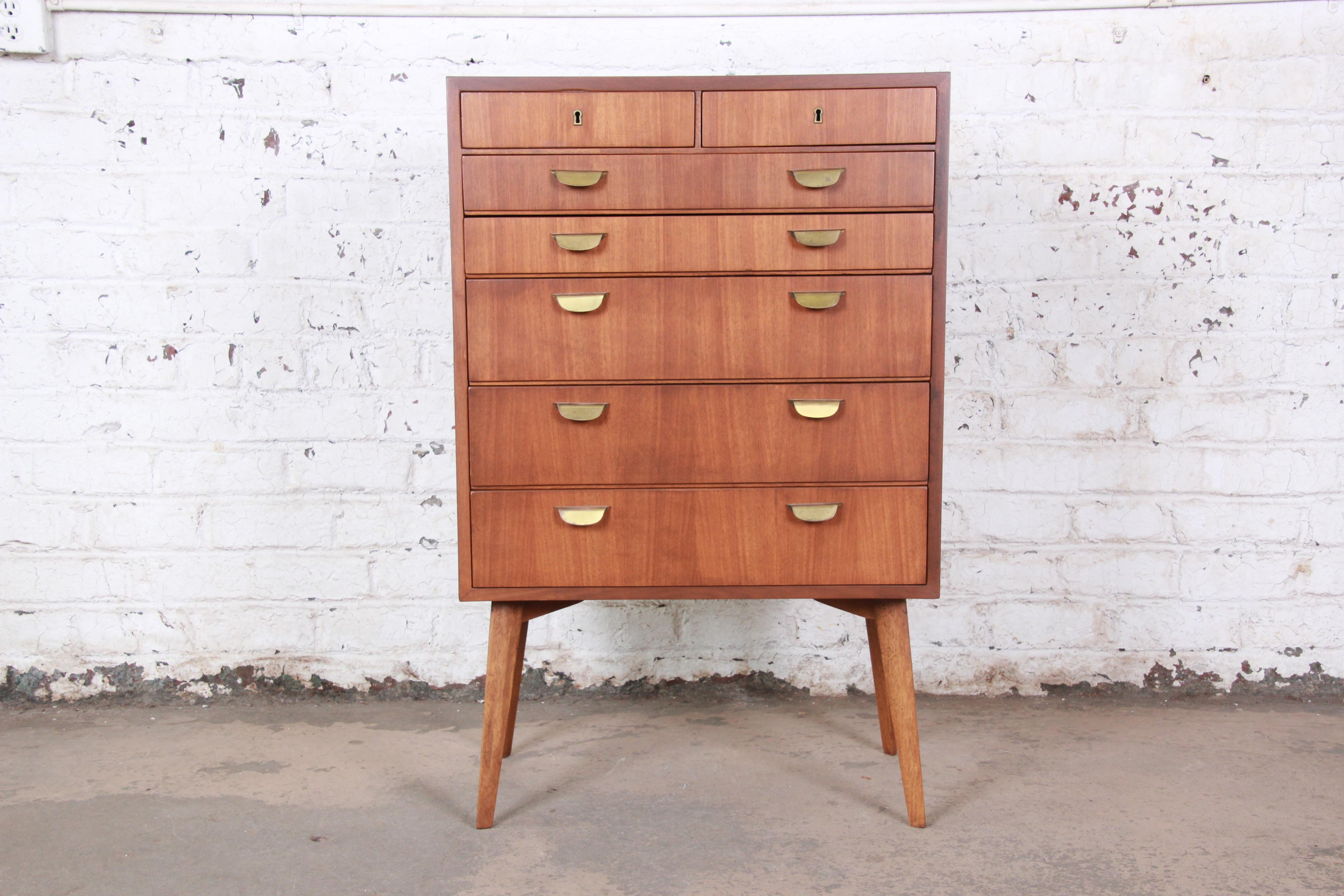 A rare and exceptional Mid-Century Modern bachelor chest designed in Germany by Helmut Magg for WK Möbel. The 7-drawer highboy dresser features clean, sleek midcentury lines with Minimalist design and a beautiful walnut wood grain. It is well