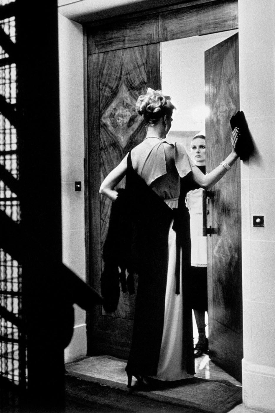 In "16th Arrondissement, Paris, 1975" Helmut Newton subtly plays on the relationship between lady and maid. A forcefully placed hand on the side of the door and intense matching of gaze accentuates the suggestive tension of the image heightened by