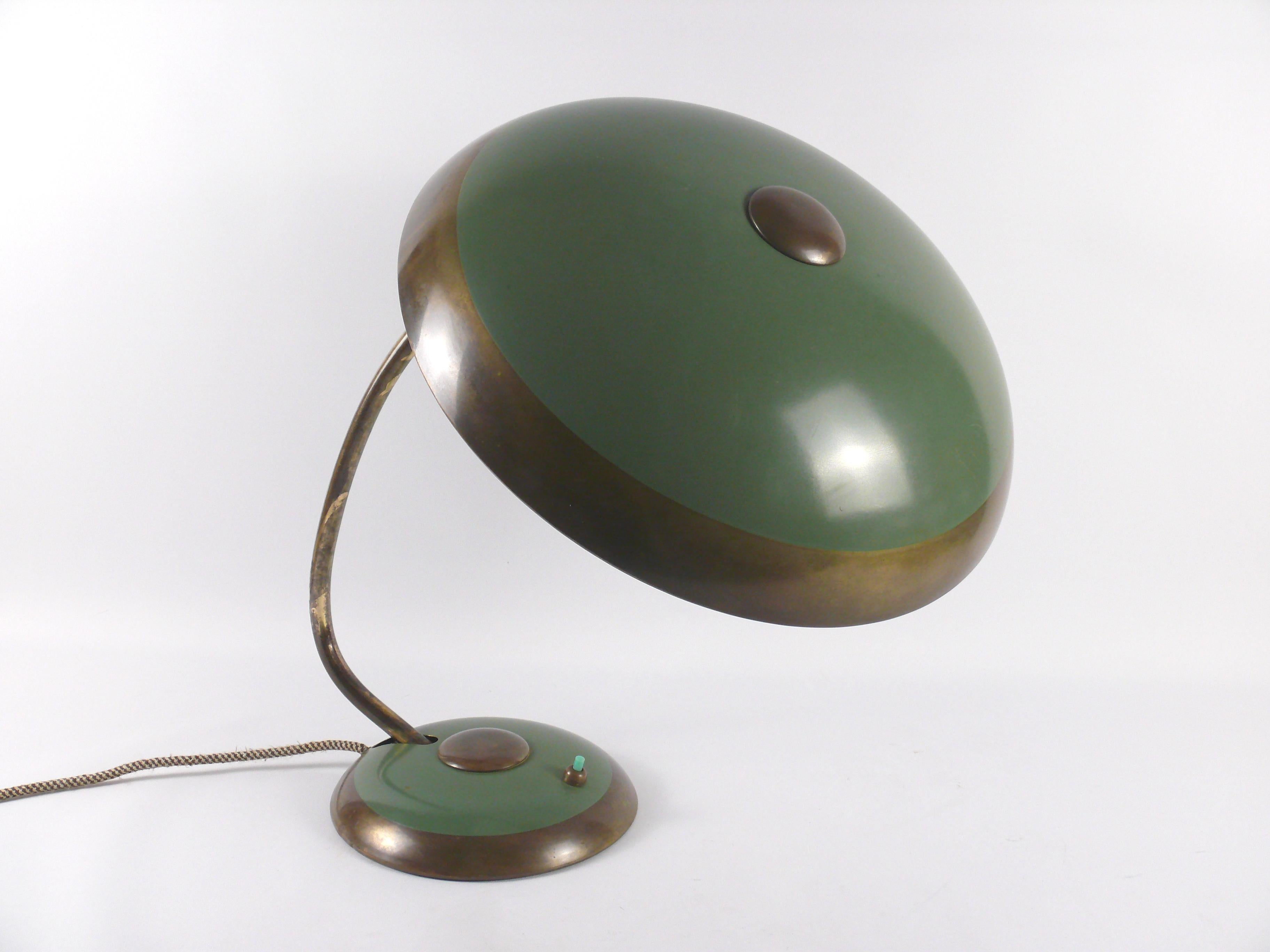 Well-preserved Helo table lamp, timeless classic from the 1950s. The contrast between the green surfaces and the brass parts with patina gives the lamp a noble calm. Stylistically, the design of the lamp is based on the lamps of the Bauhaus period.