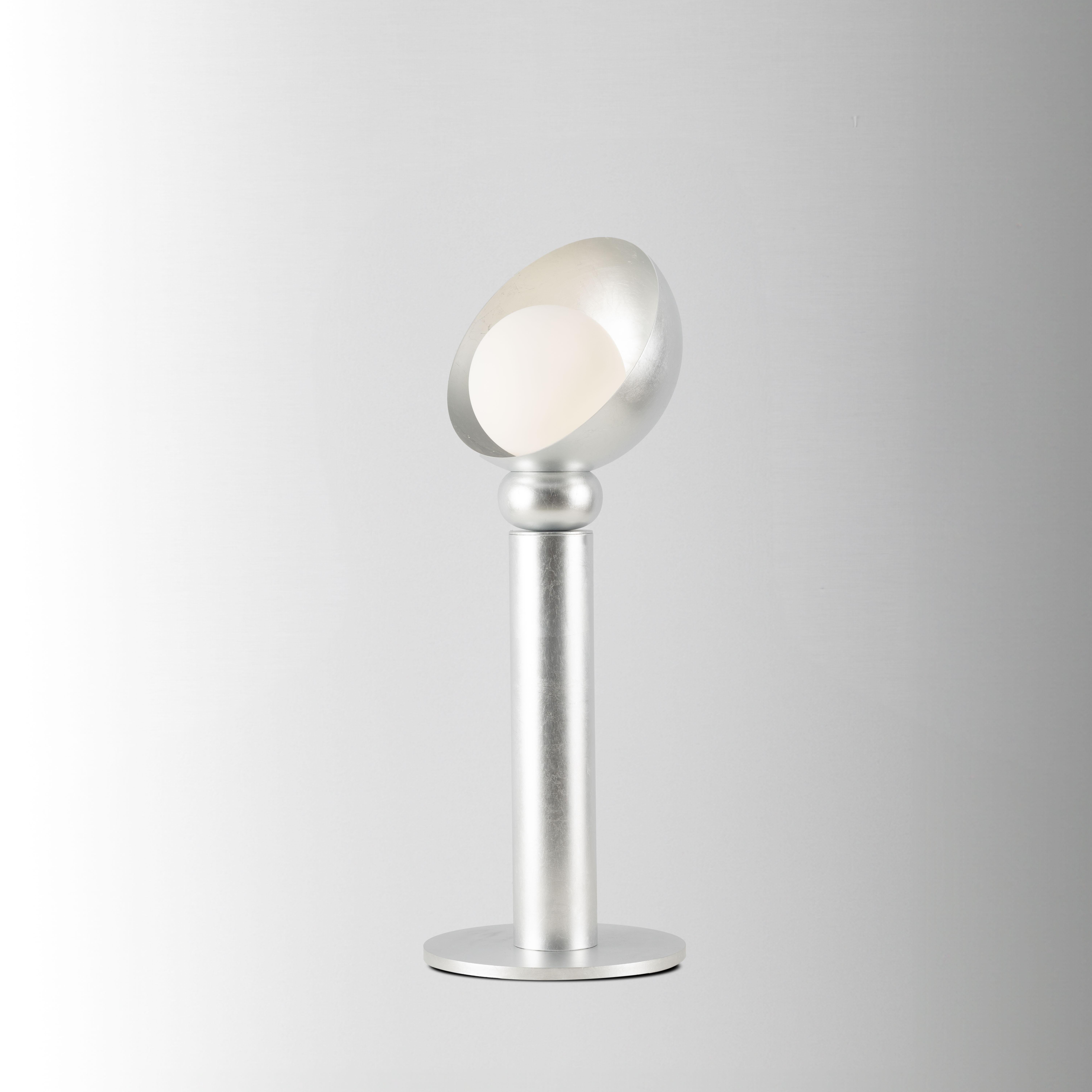 Lampe de table Helo, 21632, par Stillux Illuminazione
Dimensions : D 27 x H 70 cm.
MATERIAL : Acier, fer, verre, feuille d'argent.

Disponible en feuille d'or, feuille d'argent, noir et or, noir et argent ou noir total. Veuillez nous