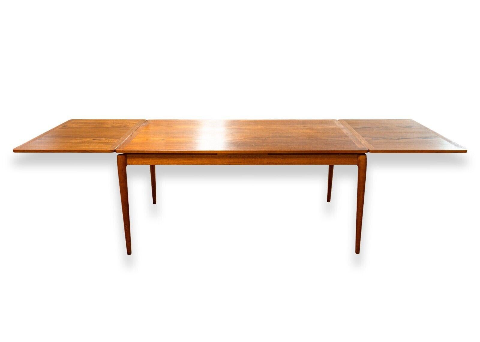 A Heltborg Mobler Domus Danica Danish mid century modern rosewood extendable dining room table. This is an absolutely stunning dining room table with classic and timeless Danish design. This piece features a vintage and rare rosewood construction