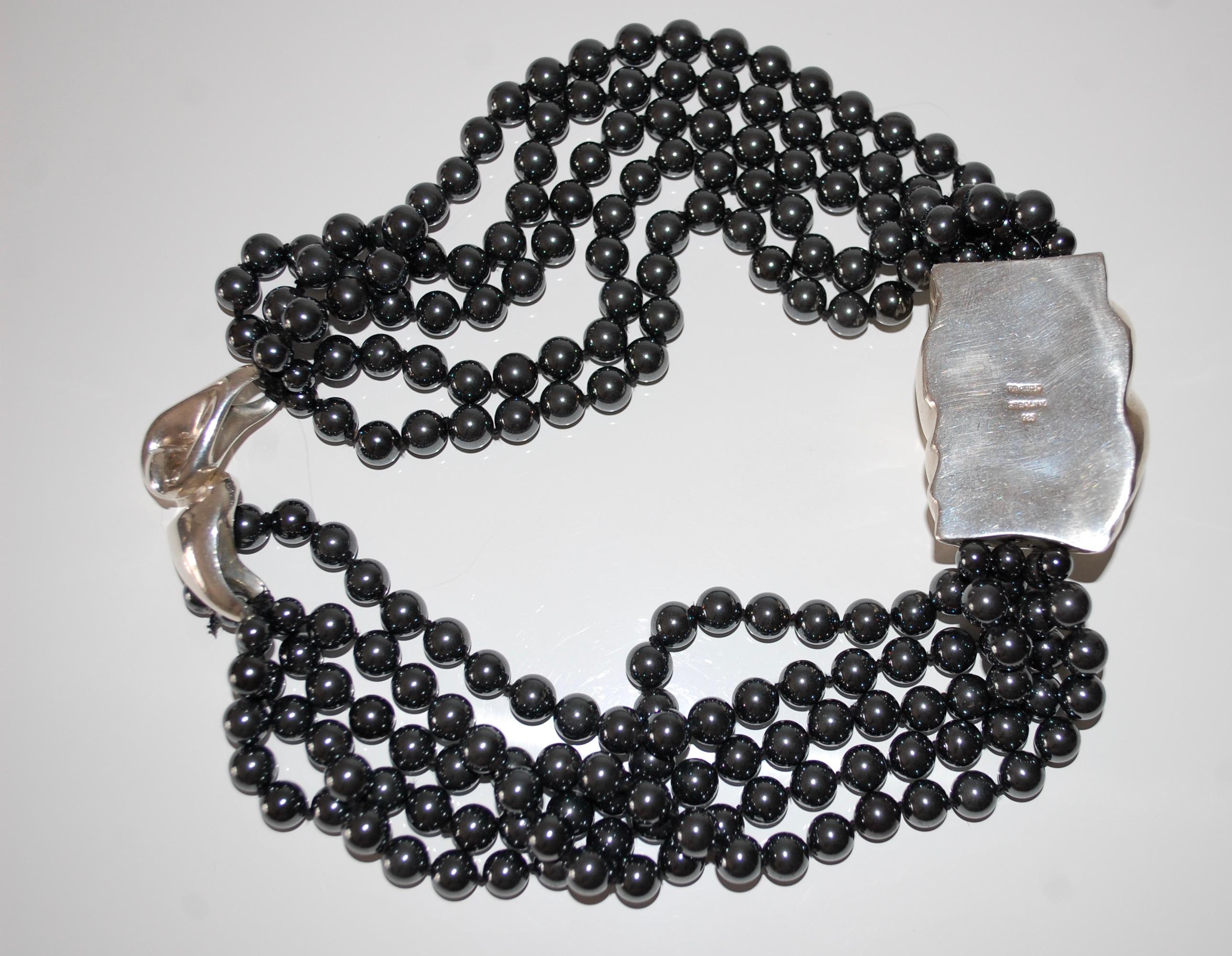 Patricia von Musulin
Collana a torsione in ematite e argento sterling.
Progettato con cinque fili di perle di ematite tonde e graduate di circa 7 mm e un elegante ciondolo in argento sterling scolpito al centro.  
Firmato von Musulin
circa 19,5