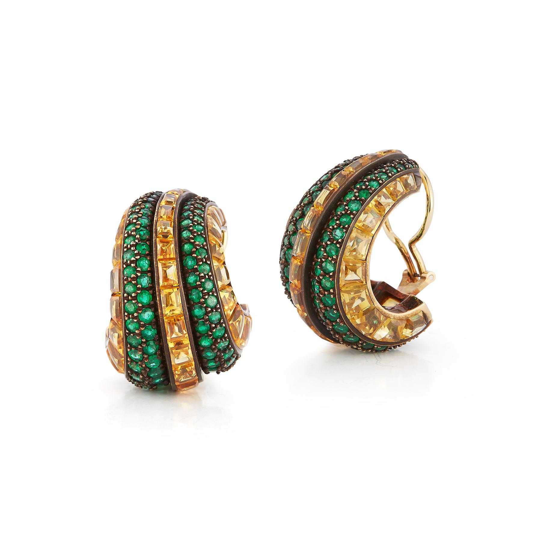 Hemmerle Yellow Sapphire and Emerald Earrings

Stylized hoop design, set with three rows of buff-top yellow sapphires, accented by two rows of round emeralds
together with signed box
signed Hemmerle, with maker's mark

App 81.98 carats of Yellow