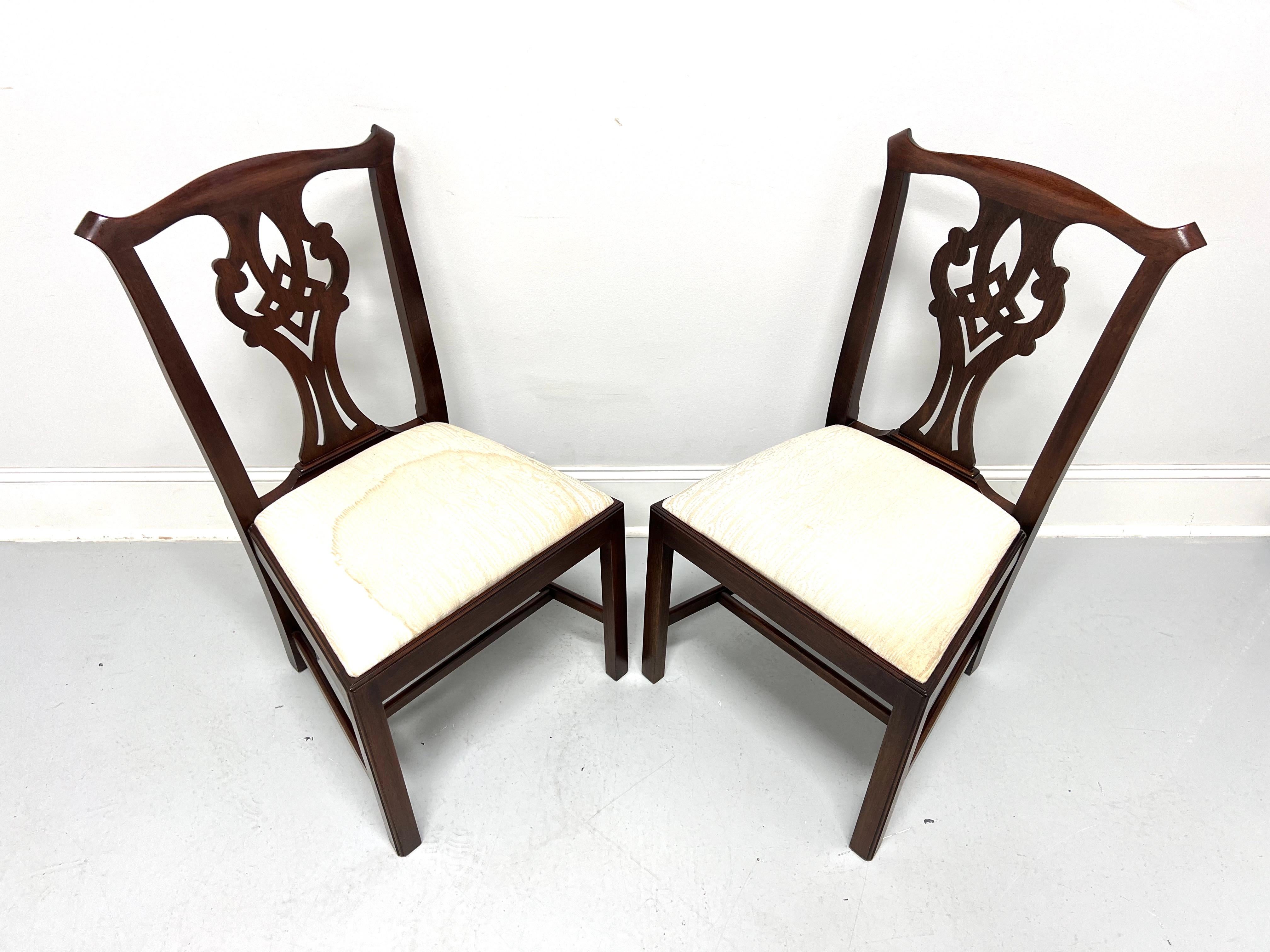 A pair of Chippendale style dining side chairs by Henkel Harris, of Winchester, Virginia, USA. Solid mahogany, carved crest rail & backrest, neutral cream color silk fabric upholstered seat, straight legs, and stretchers. Made circa 1976. 

Style #: