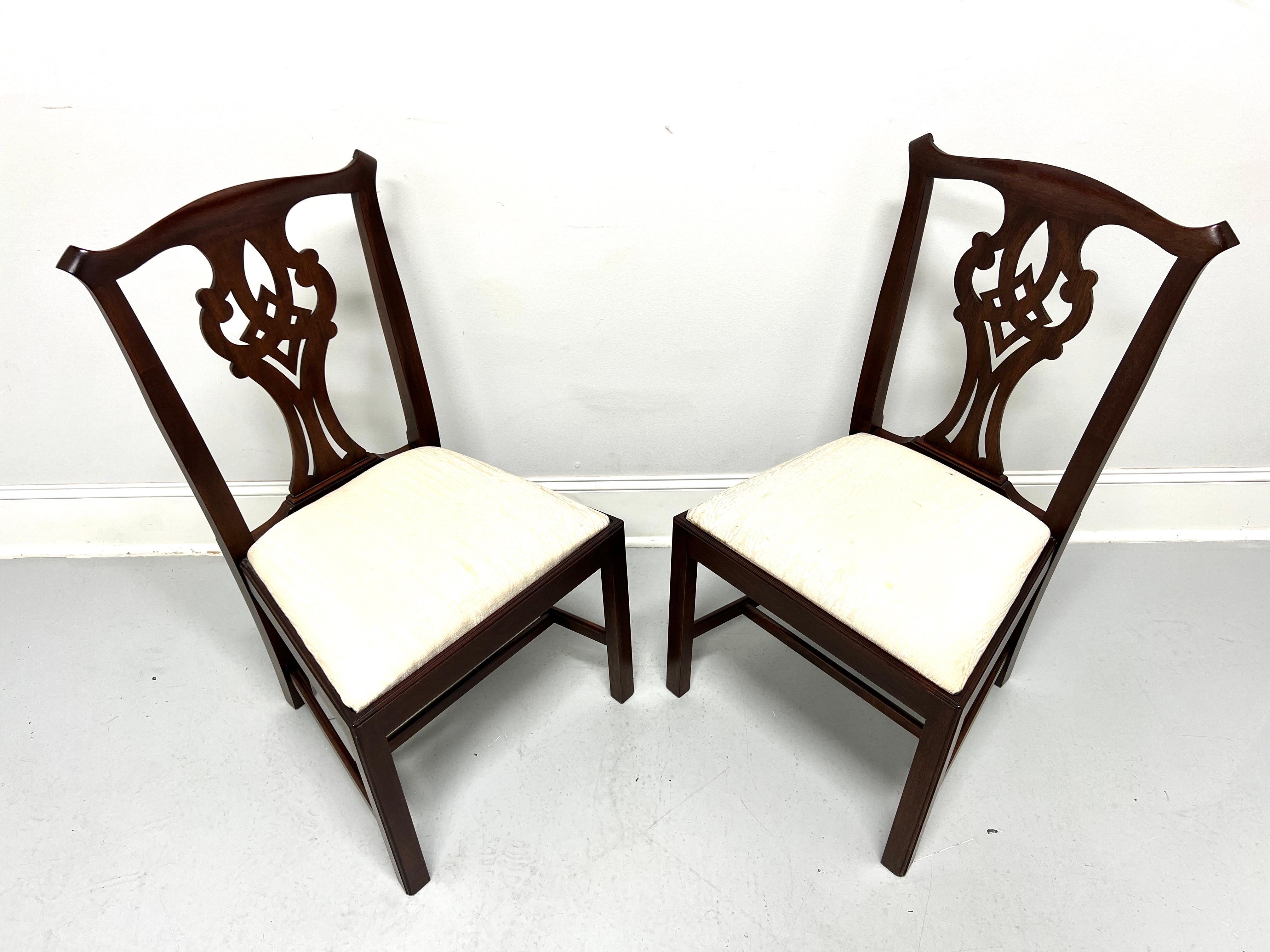 A pair of Chippendale style dining side chairs by Henkel Harris, of Winchester, Virginia, USA. Solid mahogany, carved crest rail & backrest, neutral cream color silk fabric upholstered seat, straight legs, and stretchers. Made circa 1976. 

Style #: