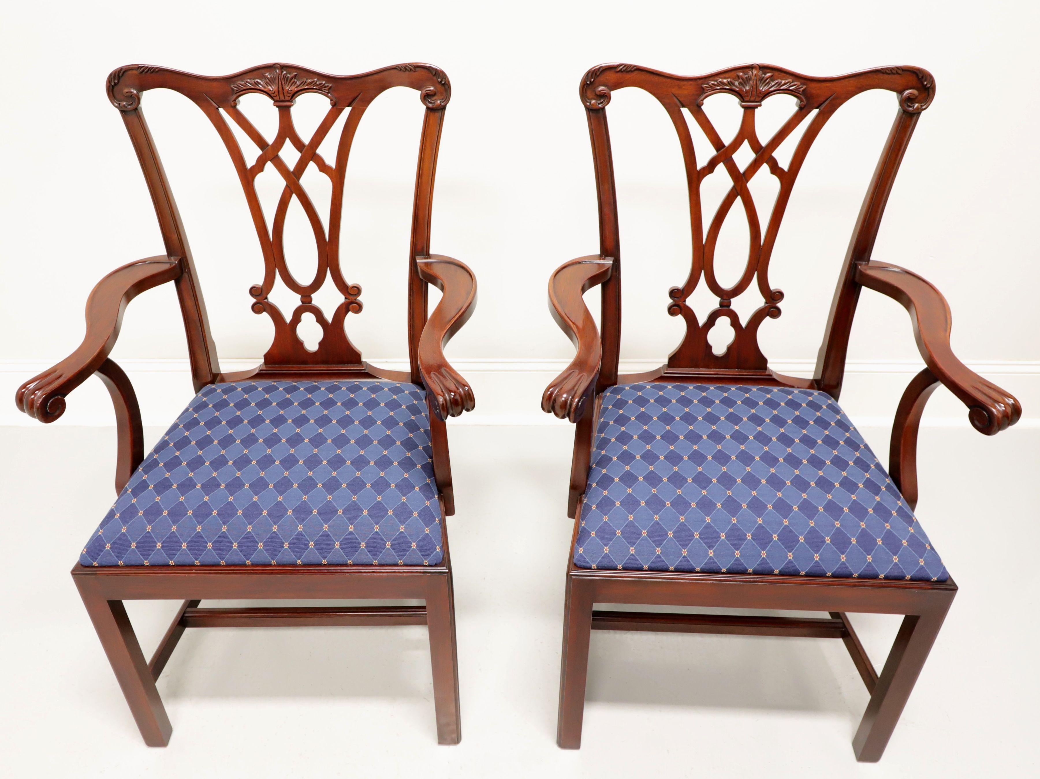 A pair of Chippendale style dining armchairs by Henkel Harris, of Winchester, Virginia, USA. Solid Mahogany, carved crest rail, backrest, scroll arms, straight legs and stretchers. Seats upholstered in a blue colored diamond patterned fabric. Made
