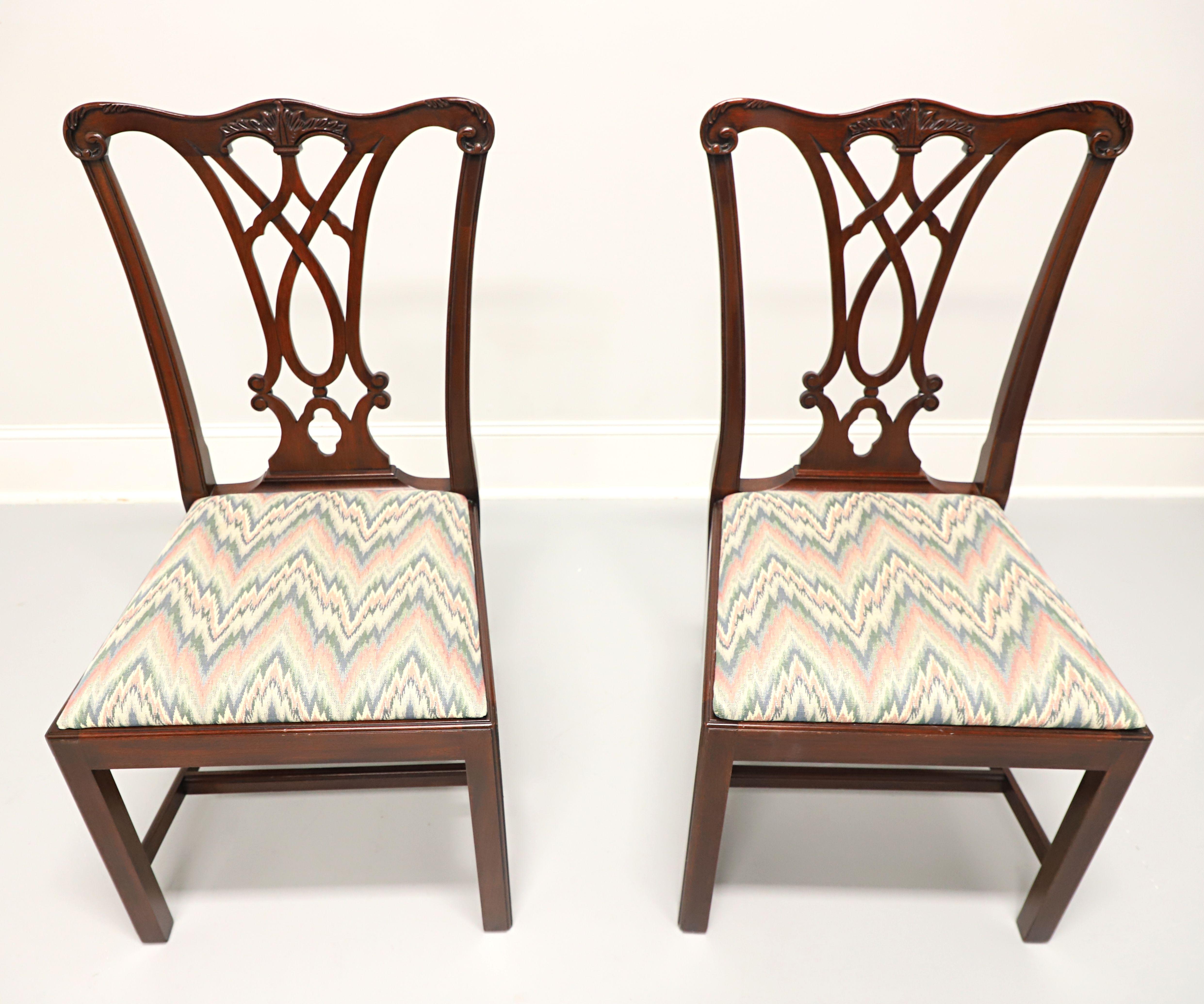 A pair of Chippendale style dining side chairs by Henkel Harris, of Winchester, Virginia, USA. Solid mahogany, carved crest rail & backrest, multi-color flame stitch pattern fabric upholstered seat, straight legs and stretchers. Made in 1992.