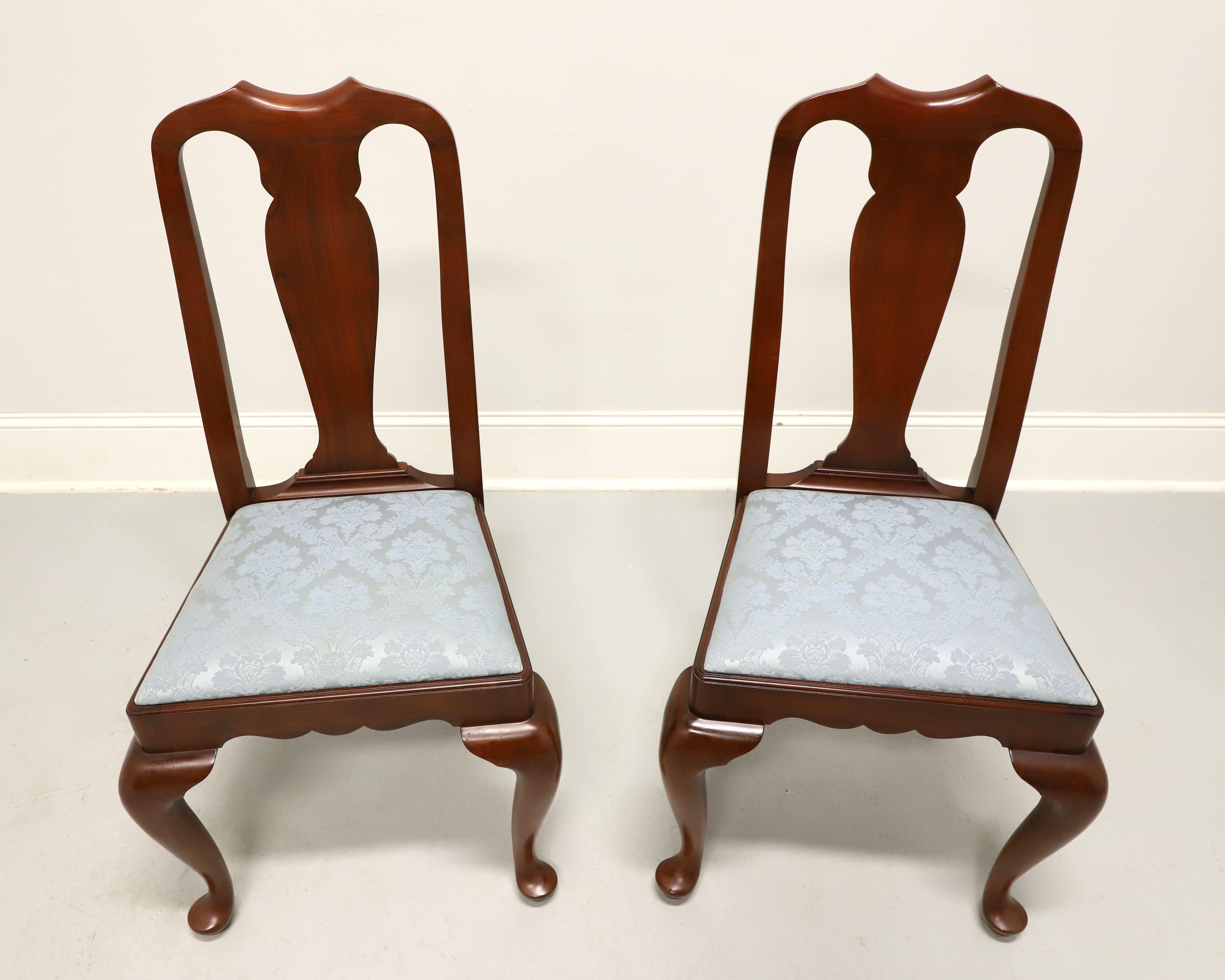 A pair of Queen Anne style dining side chairs by Henkel Harris, of Winchester, Virginia, USA. Solid wild black cherry wood, carved crest rail, carved center backrest, upholstered seat in a light blue brocade fabric, carved apron, cabriole legs and