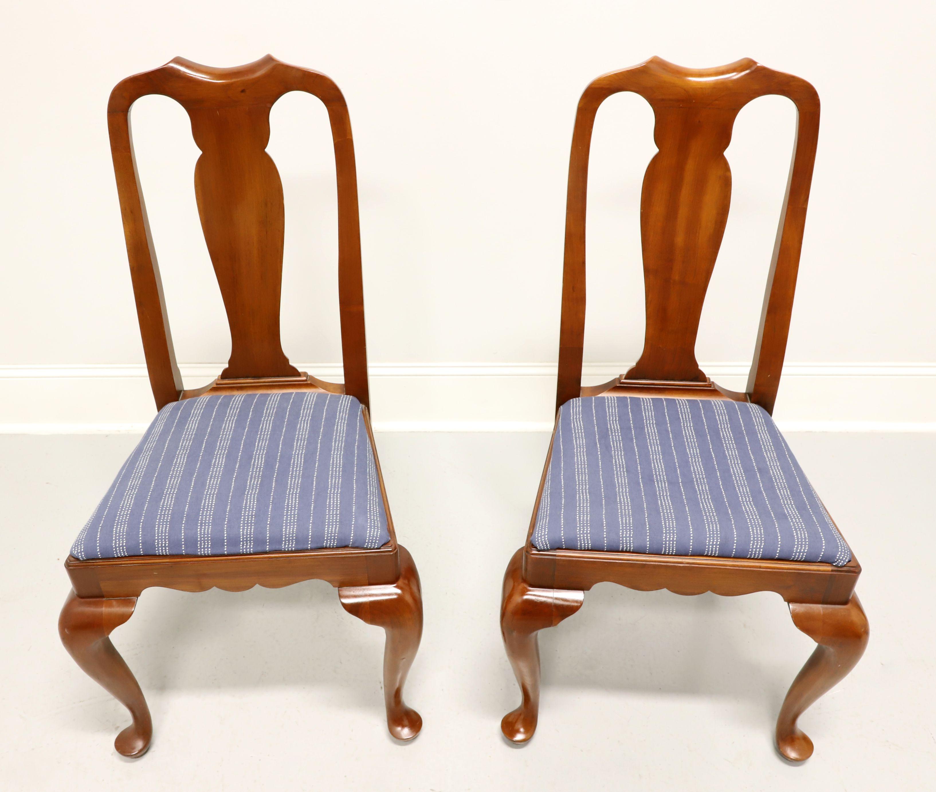 A pair of Queen Anne style dining side chairs by Henkel Harris, of Winchester, Virginia, USA. Solid wild black cherry, carved center backrest, upholstered seat in a dark blue & white stripe fabric, carved apron, cabriole legs and pad feet. Made in