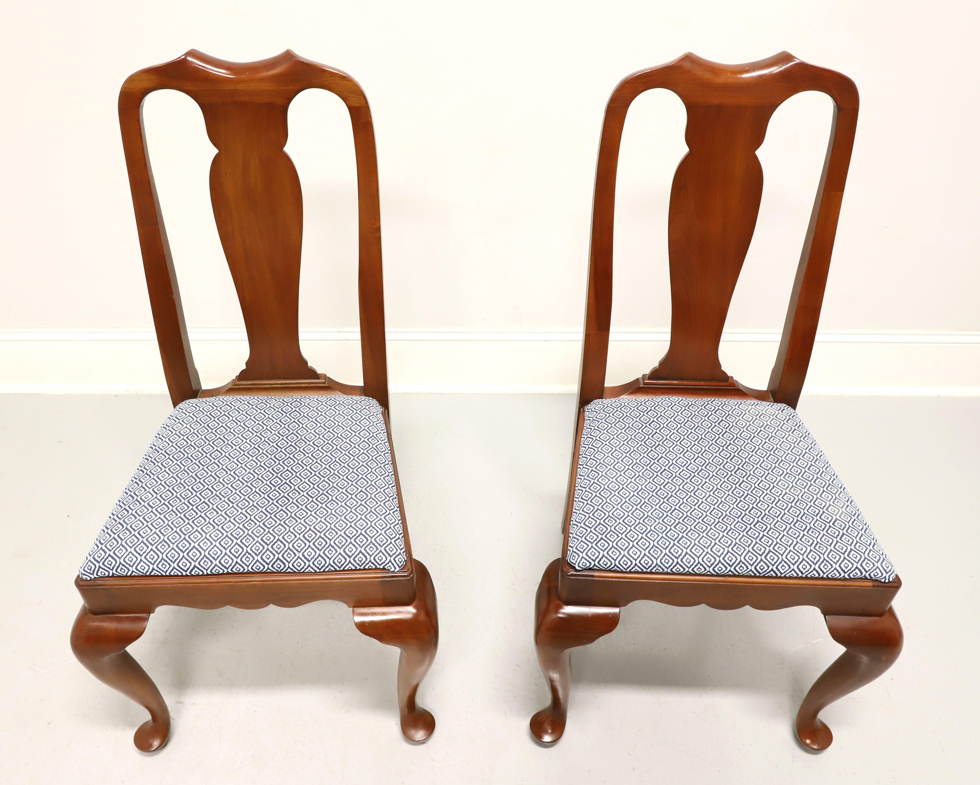 A pair of Queen Anne style dining side chairs by Henkel Harris, of Winchester, Virginia, USA. Solid wild black cherry, carved center backrest, upholstered seat in a light blue & white patterned fabric, carved apron, cabriole legs and pad feet. Made