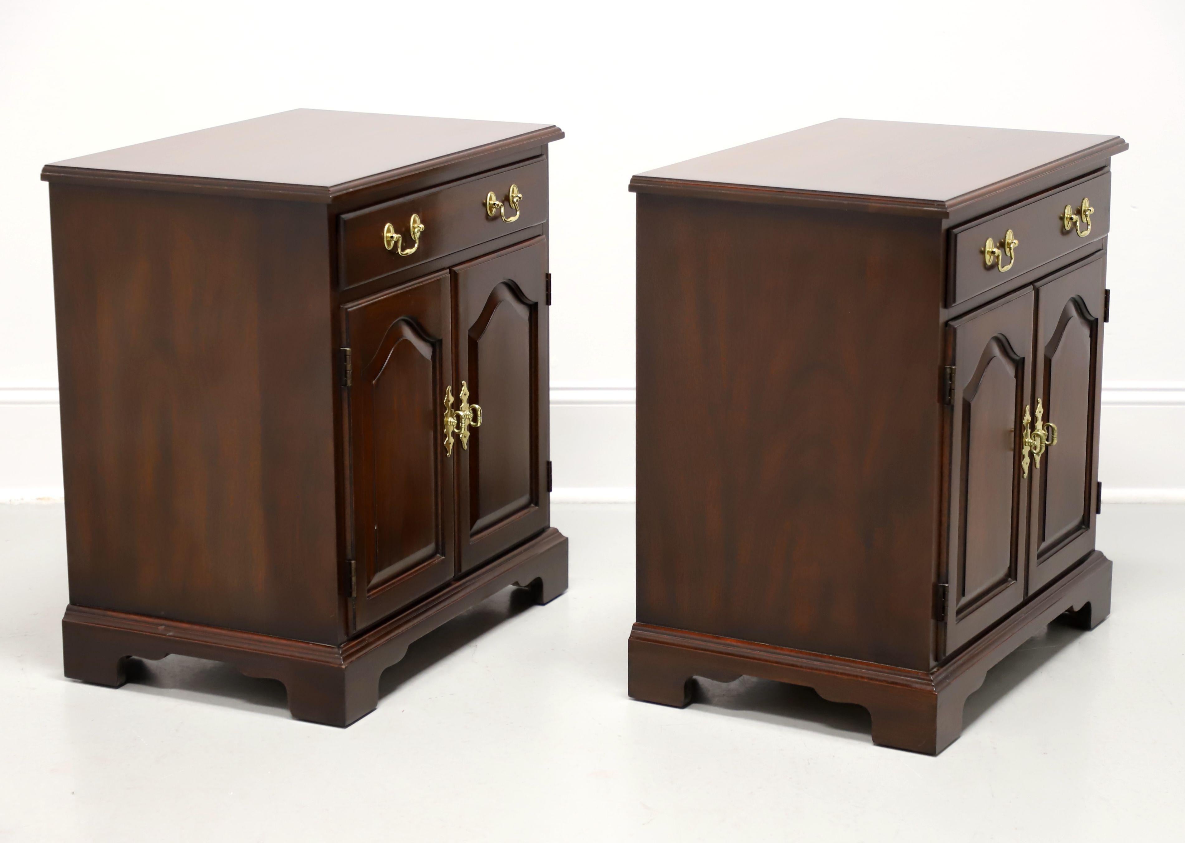 A pair of Chippendale style nightstands by Henkel Harris, of Winchester, Virginia, USA. Solid mahogany with brass hardware, ogee edge to the top, ogee edge at base, and bracket feet. Features one drawer of dovetail construction over a dual door
