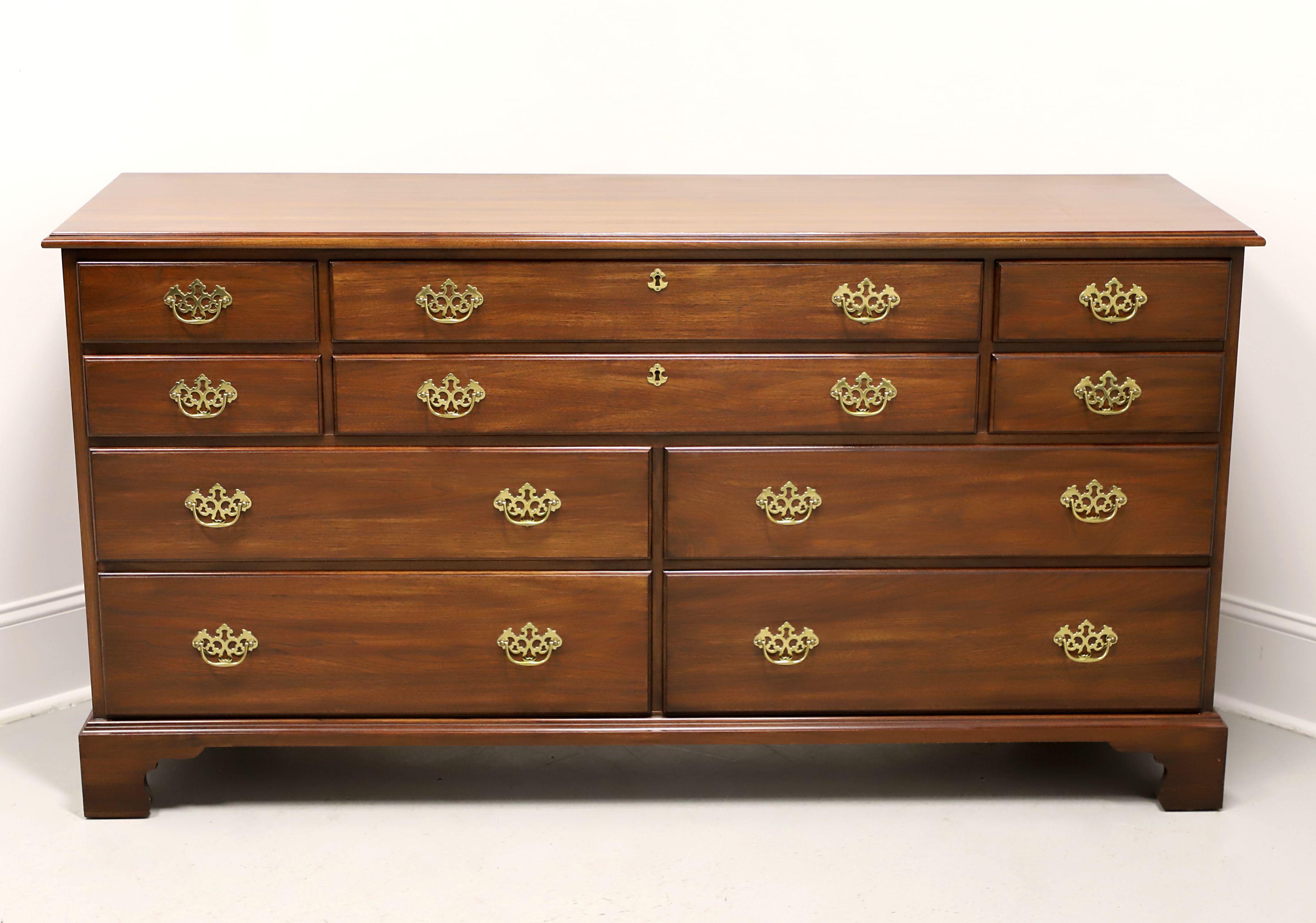 A triple dresser in the Chippendale style by Henkel Harris, of Winchester, Virginia, USA. Solid genuine black walnut, decorative brass hardware, ogee edge to top, and bracket feet. Features ten various size drawers of dovetail construction; with two