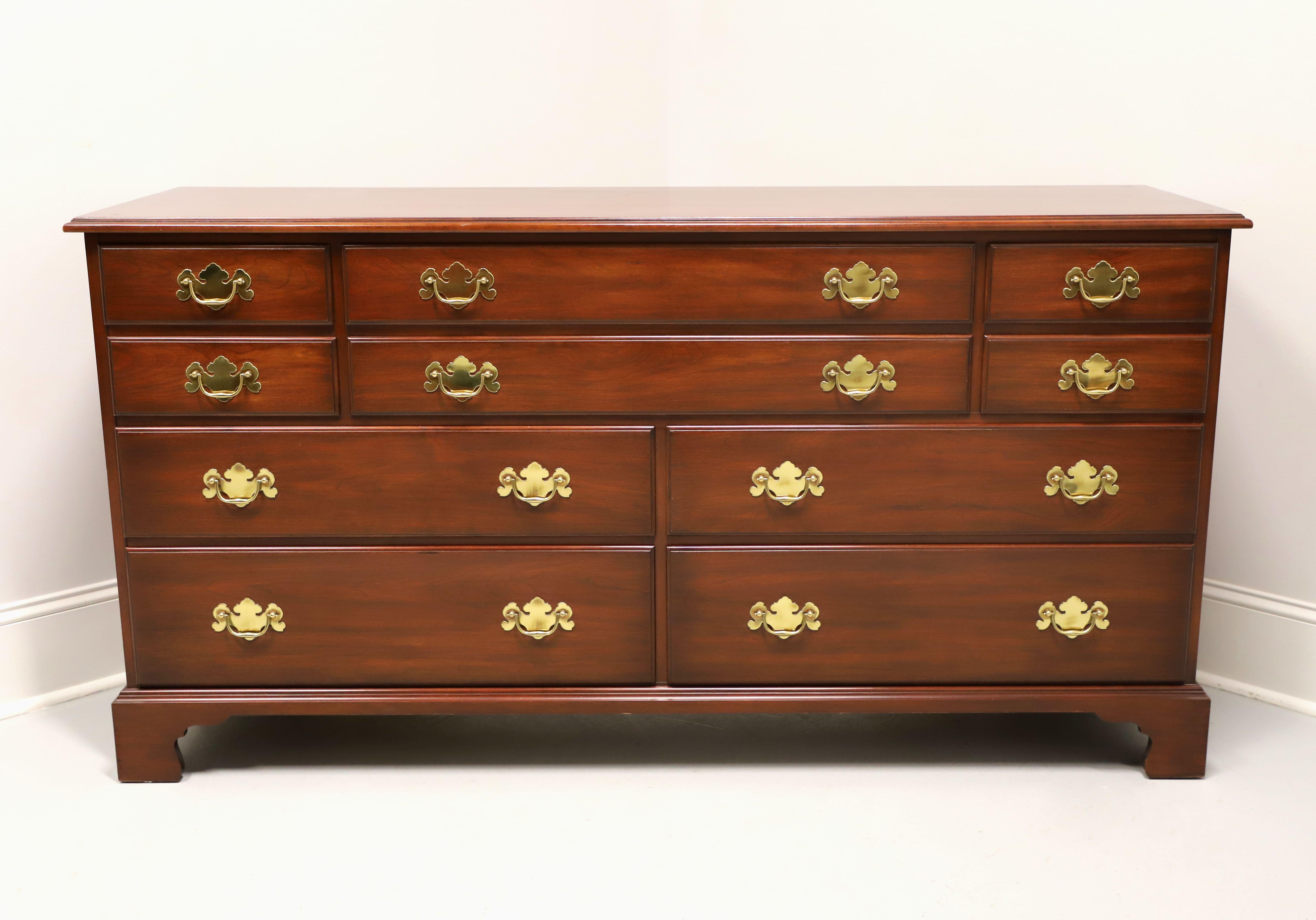 A triple dresser in the Chippendale style by Henkel Harris, of Winchester, Virginia, USA. Solid wild black cherry wood with brass hardware, ogee edge to top, and bracket feet. Features ten various size drawers of dovetail construction, with two
