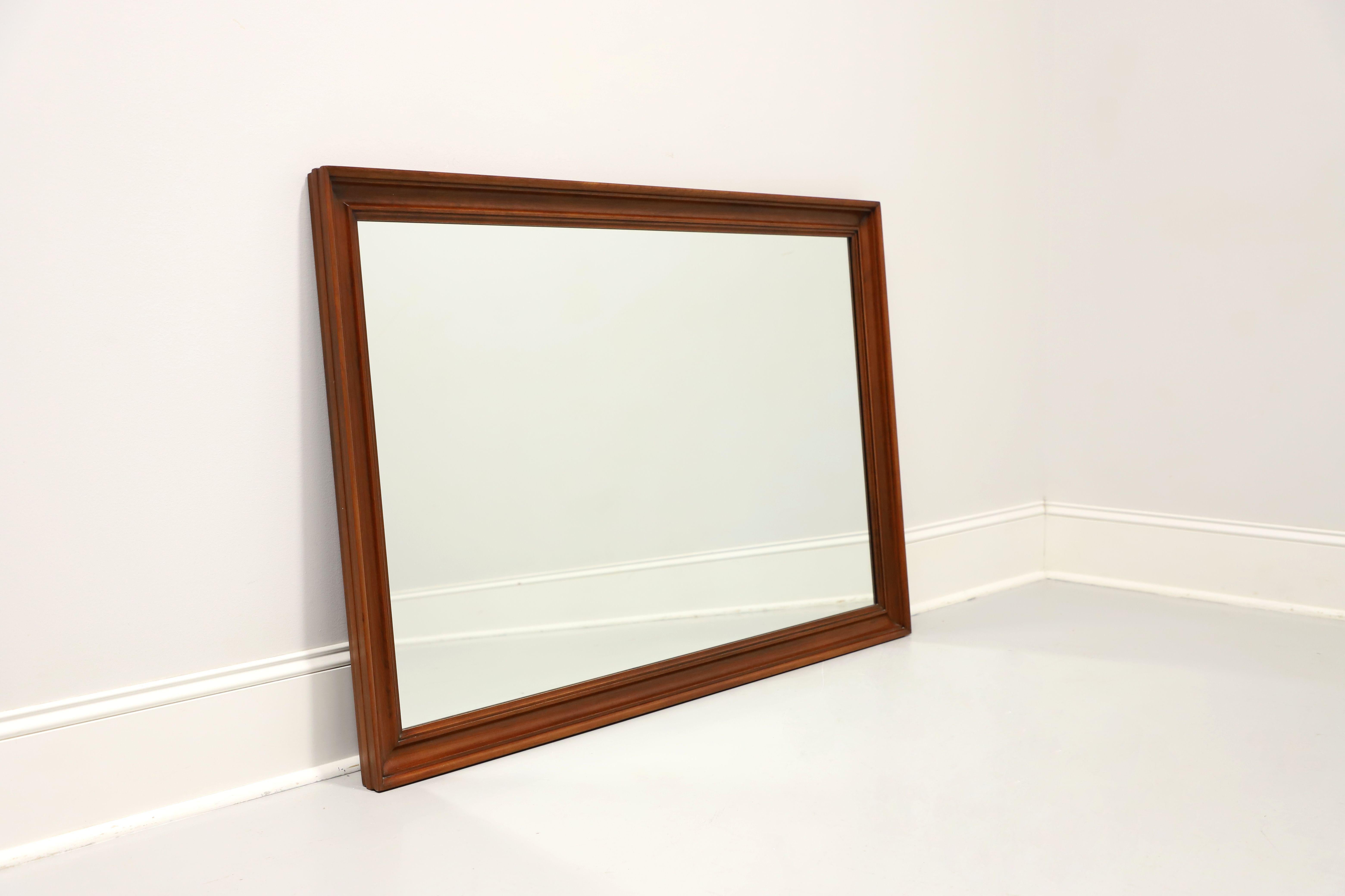 A Traditional style rectangular wall mirror by Henkel Harris. Mirror glass in a solid wild black cherry wood frame with dual hanging mounts on each side. Made in Winchester, Virginia, USA, circa 1983. 

Style #: 125, Finish #: 24

Measures:  52.5w