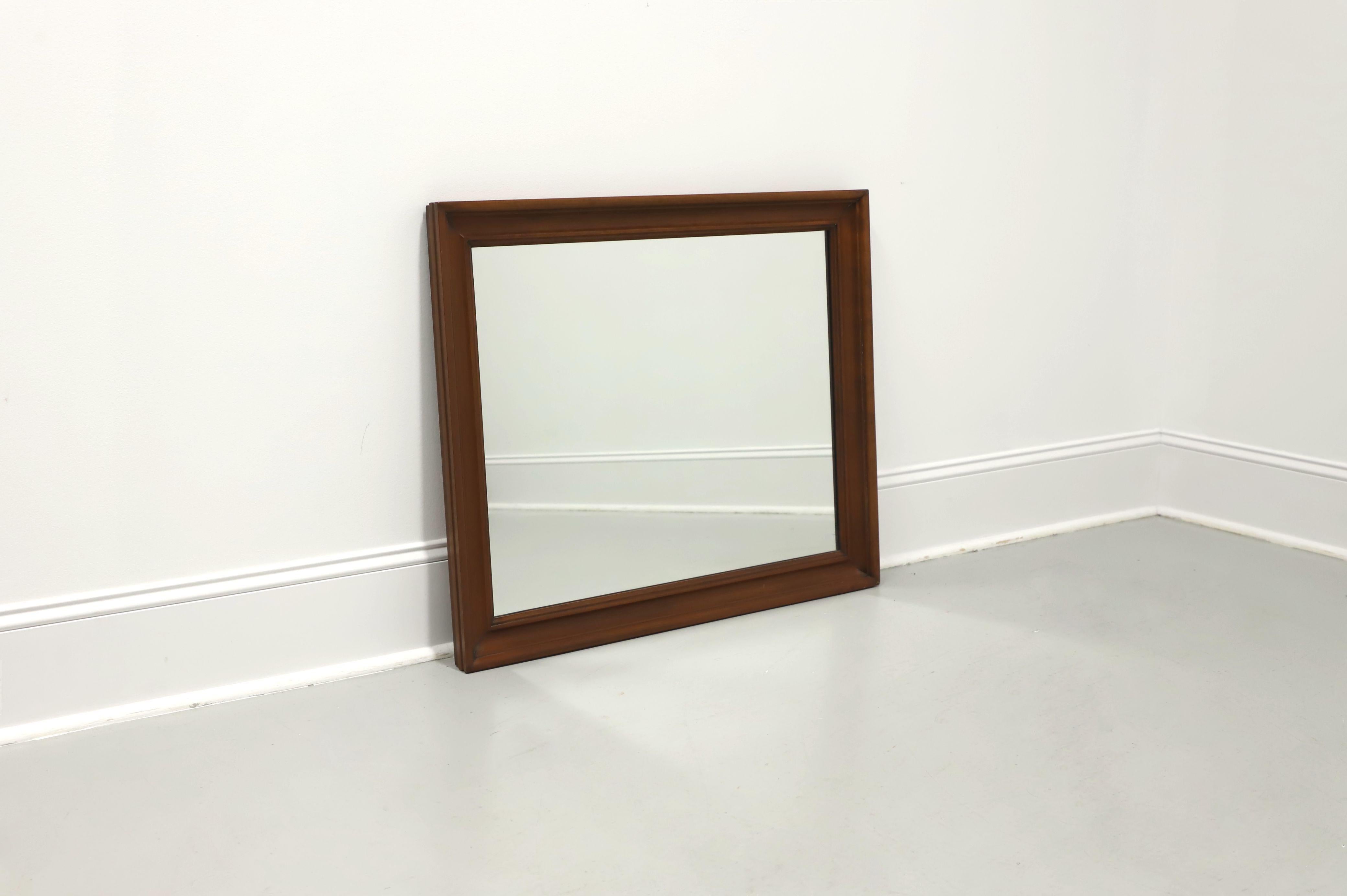 A Traditional style rectangular wall mirror by Henkel Harris, of Winchester, Virginia, USA. Mirrored glass in a solid wild black cherry wood frame with ogee framing and fluted edges. Made circa 1969.

Style #: 134, Finish #: 24 