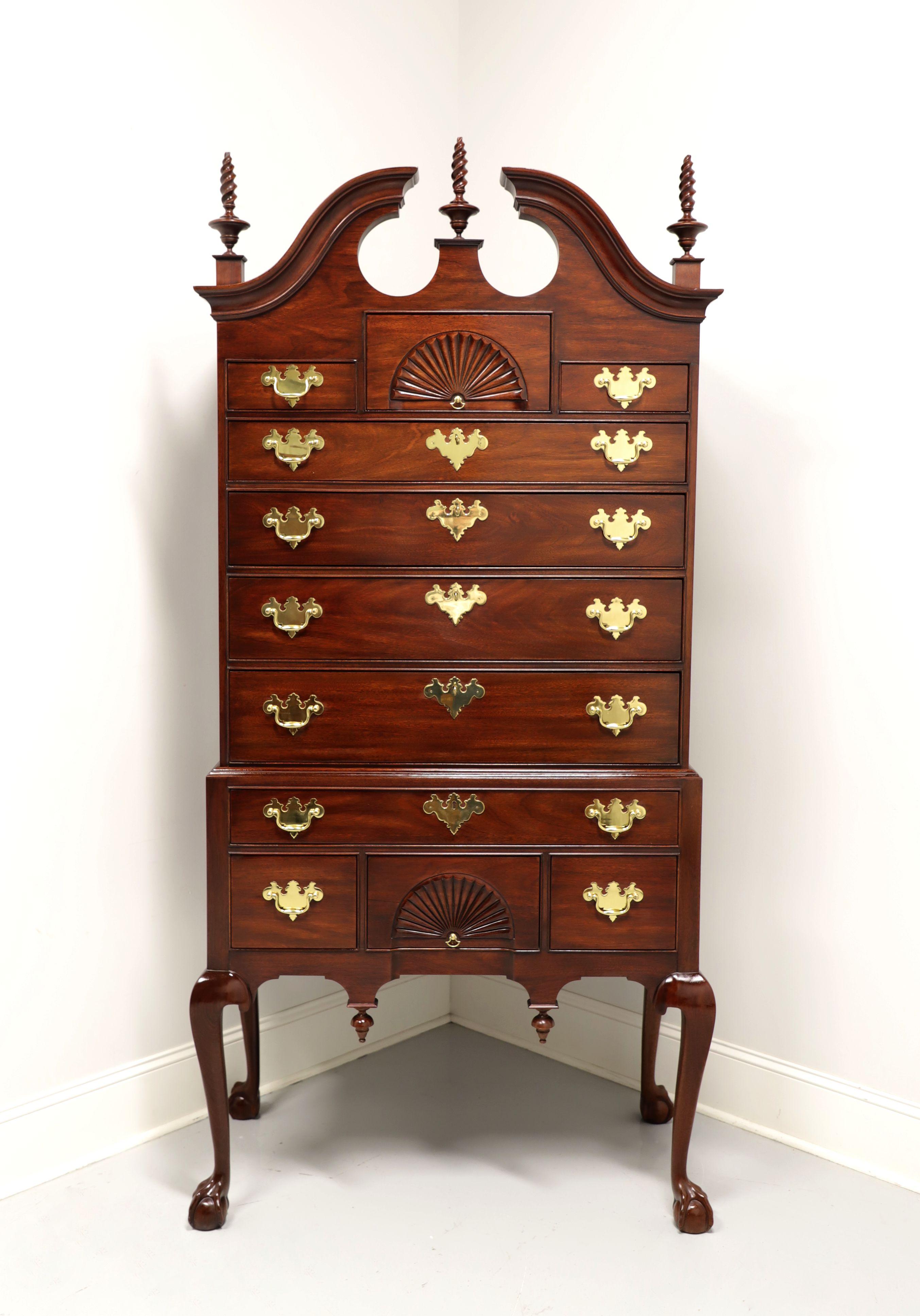 A Chippendale style highboy chest by Henkel Harris, an SPNEA (Society for the Preservation of New England Antiquities) approved 18th Century reproduction. Mahogany with brass hardware, pediment top with center & side finials, open fan carvings to