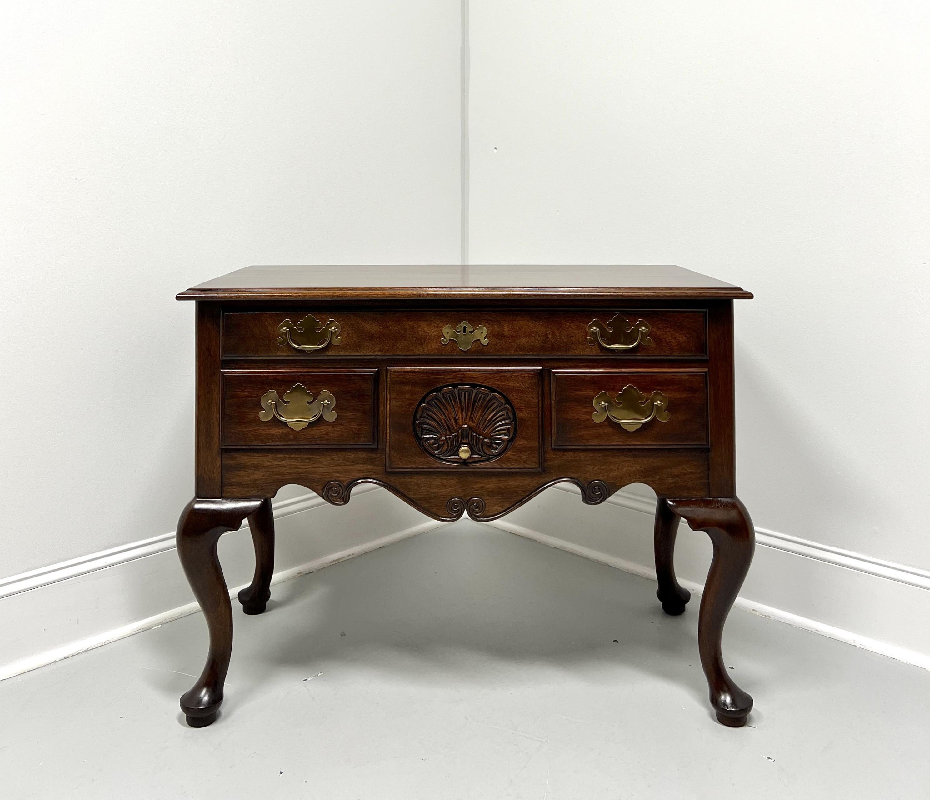 A Philadelphia lowboy chest in the Queen Anne style by Henkel Harris, of Winchester, Virginia, USA. Solid mahogany, brass hardware, ogee edge to the top, carved shell to center drawer front, carved apron, cabriole legs, and pad feet. Features one