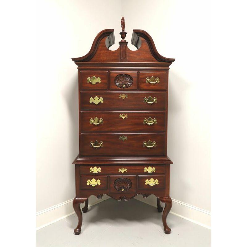 A Queen Anne style highboy chest by Henkel Harris of Winchester, Virginia, USA. Mahogany with brass hardware, a full pediment top with center finial, cabriole legs and pad feet. Features ten dovetailed drawers of various sizes, four lockable with