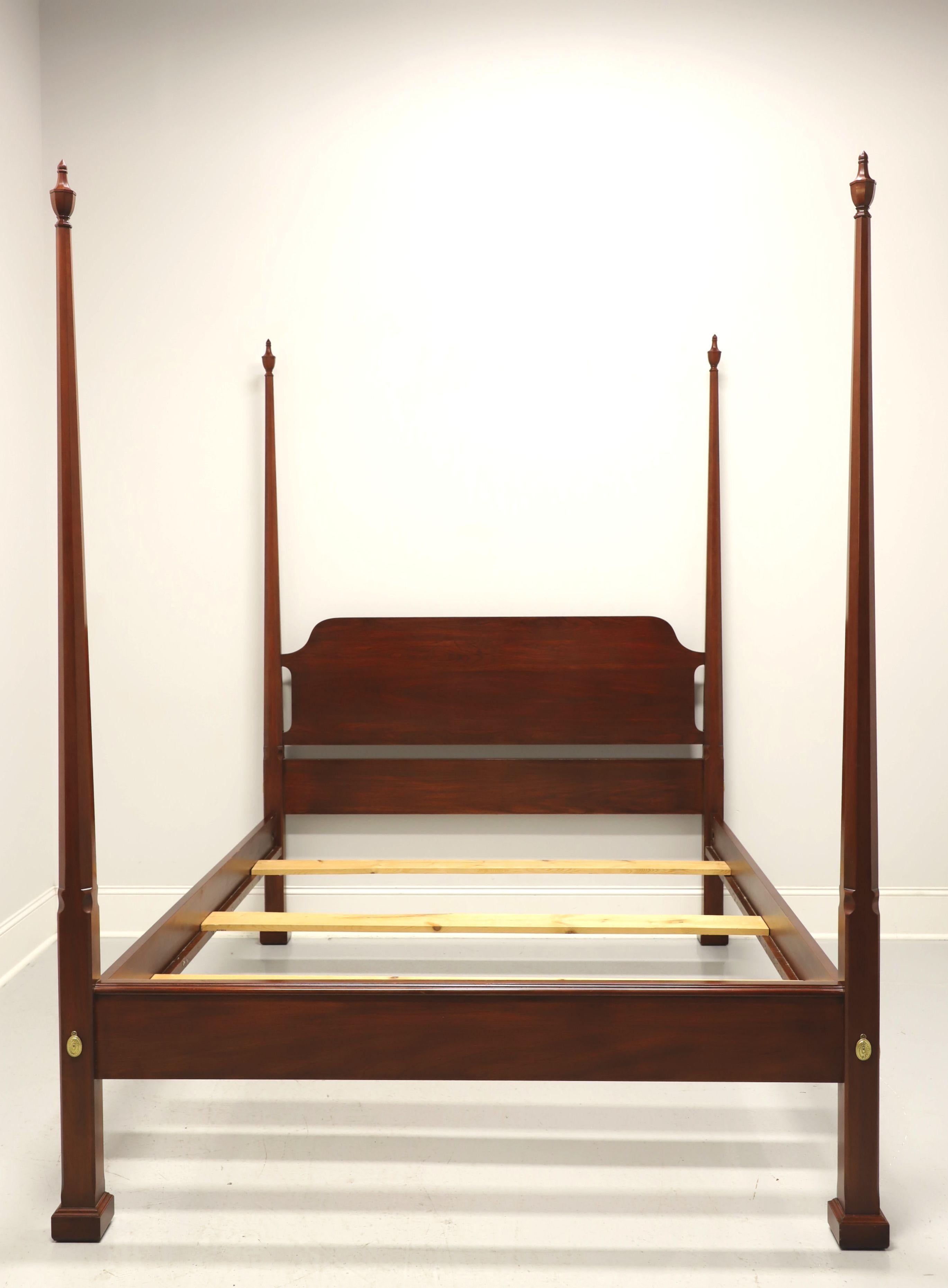 A Traditional style queen size pencil post bed by Henkel Harris, of Winchester, Virginia, USA. Solid wild black cherry with four pencil shaped posts with finials, brass covers to headboard & footboard, bolt held side rails with wood bracers and