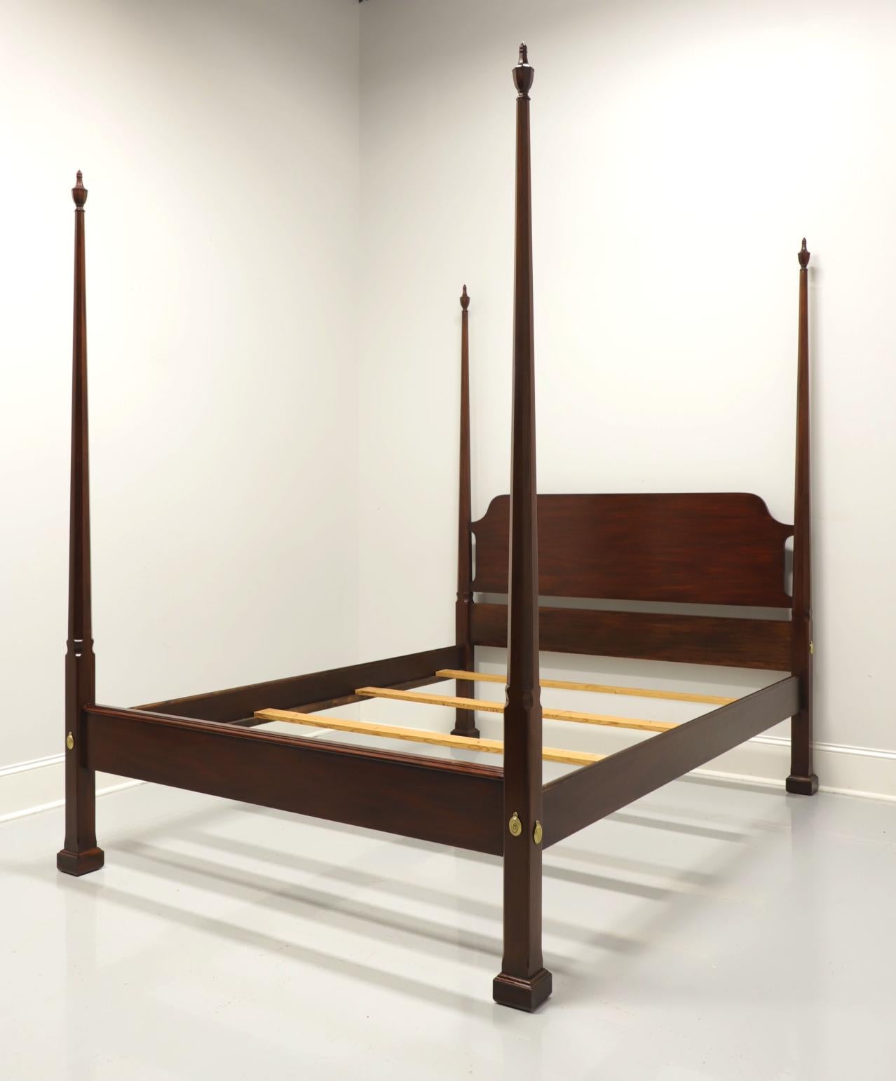 A Traditional style queen size pencil post bed by Henkel Harris, of Winchester, Virginia, USA. Solid mahogany with four pencil shaped posts with finials. Brass covers to headboard and footboard. Wood slat mattress supports. Made circa 1985.

Style
