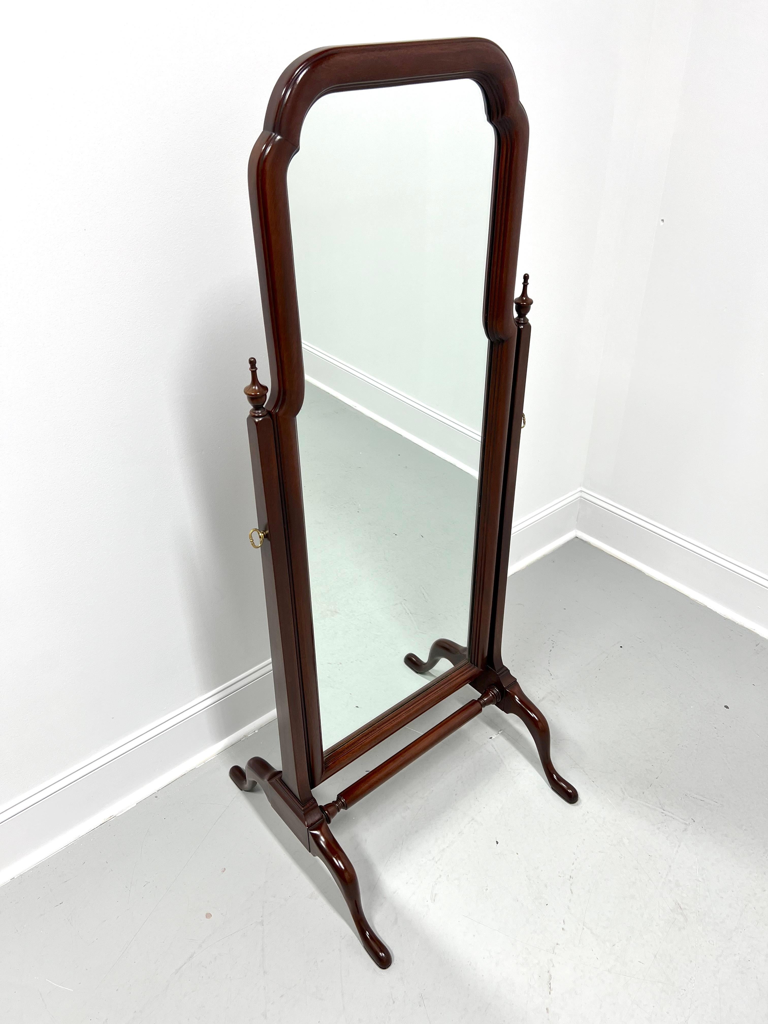 A Queen Anne style freestanding cheval dressing mirror by Henkel Harris, of Winchester, Virginia, USA. Full length mirrored glass in a solid mahogany wood frame with arched top, attached by decorative brass pivot screws to post-like sides capped by