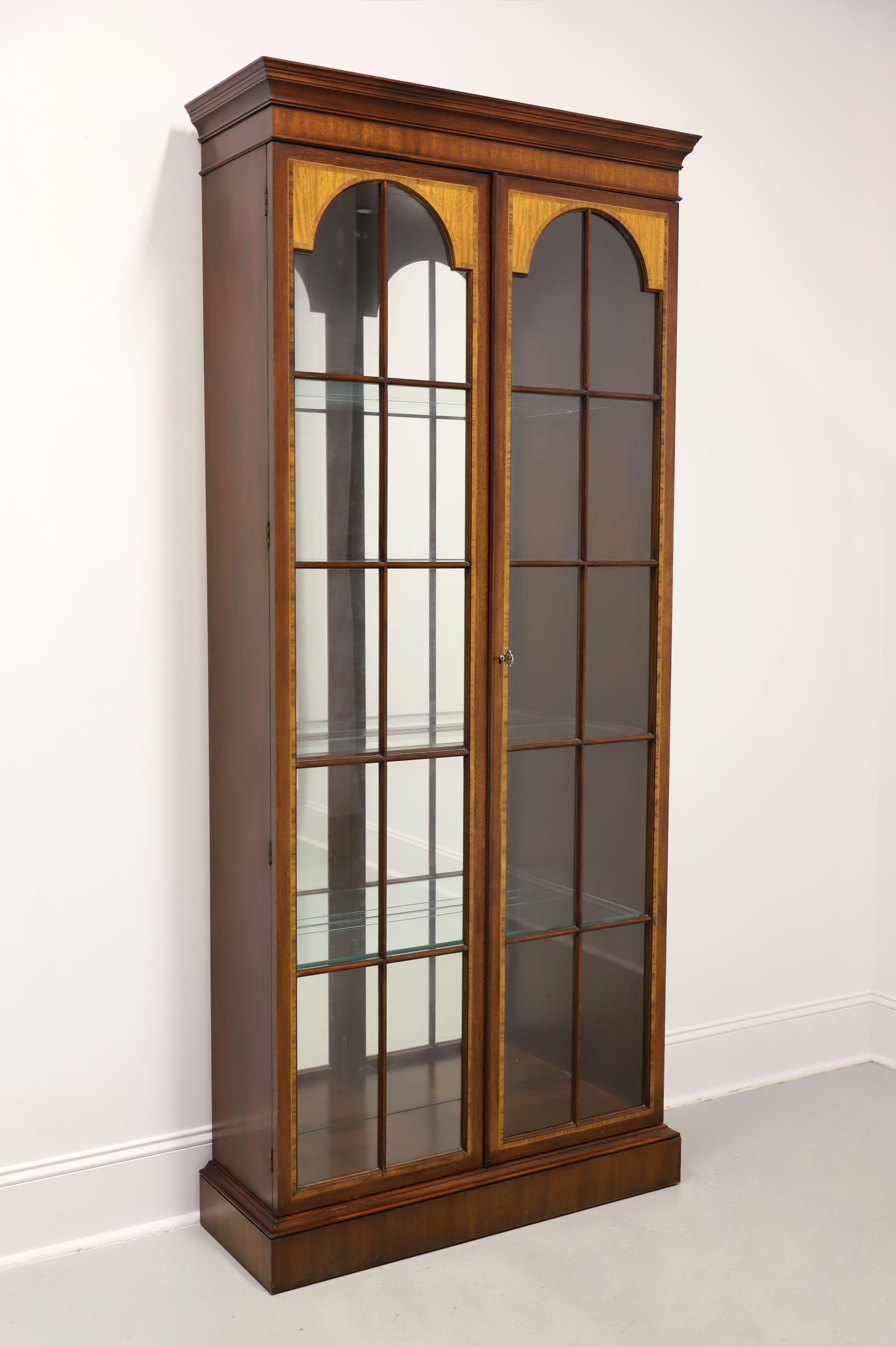 An extra tall Chippendale style curio display cabinet by Henkel Harris, of Winchester, Virginia, USA. Mahogany with inlays, brass hardware, crown moulding at the top, dual paned glass doors, mirrored back, and a solid base. Interior of cabinet